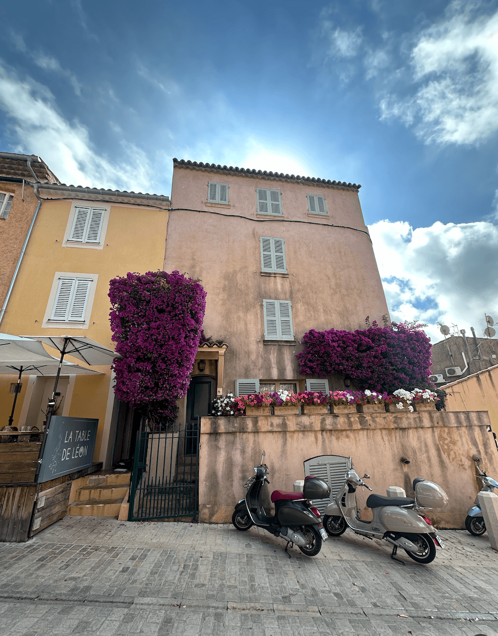 View of an old building with two scooters parked out front on a sunny afternoon