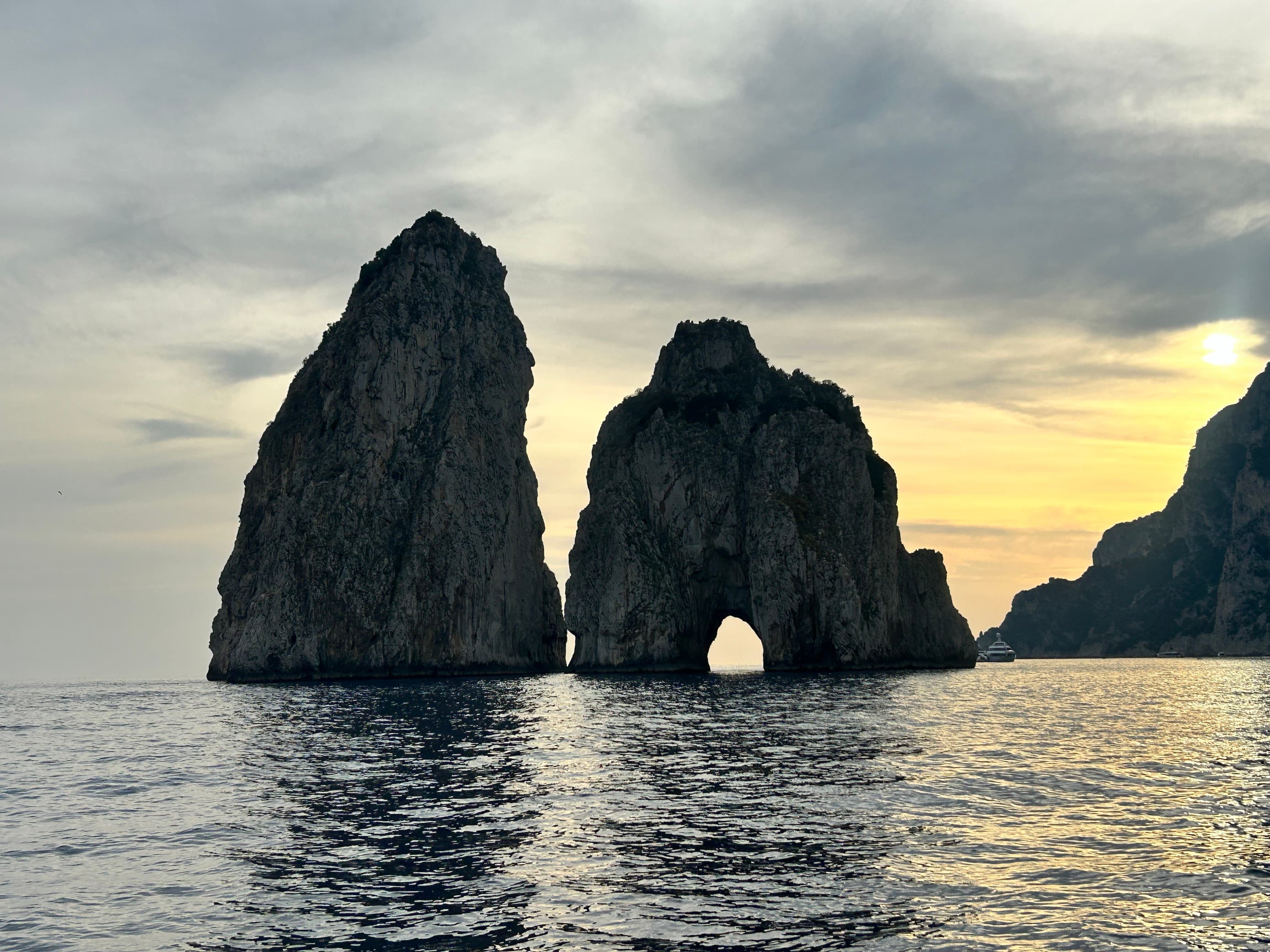 View of rock formations at sea during sunset