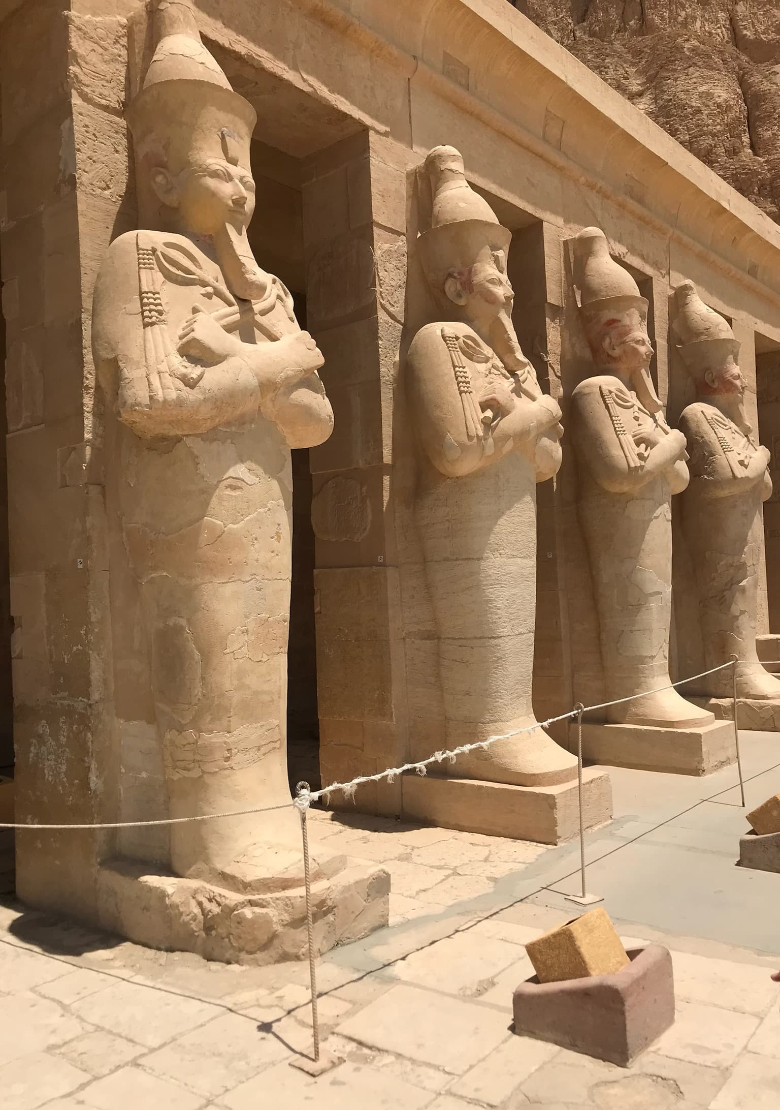 A line of large, ancient stone carvings in the shape of men with their arms crossed