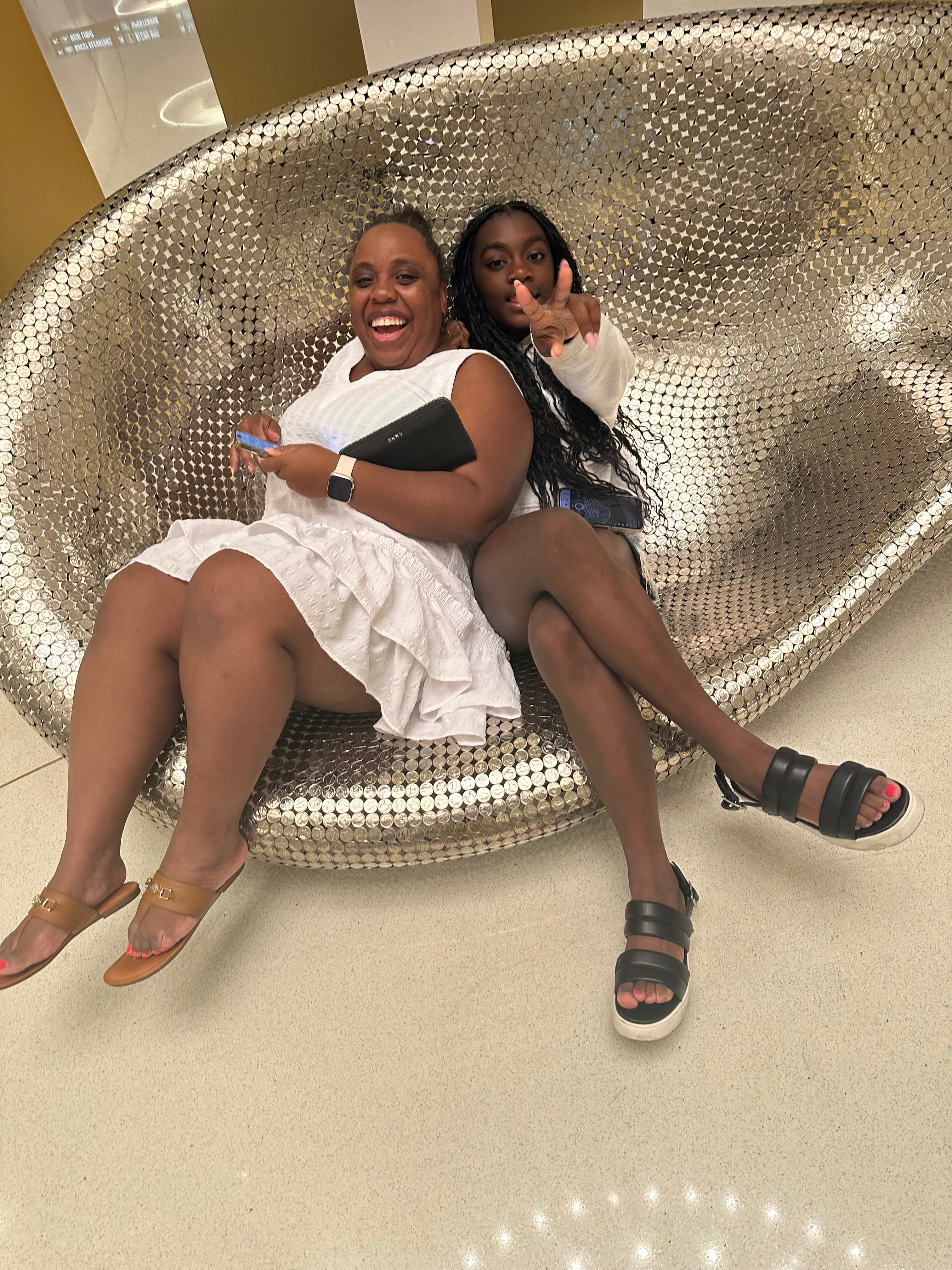 Advisor and friend sitting in a large shiny silver chair