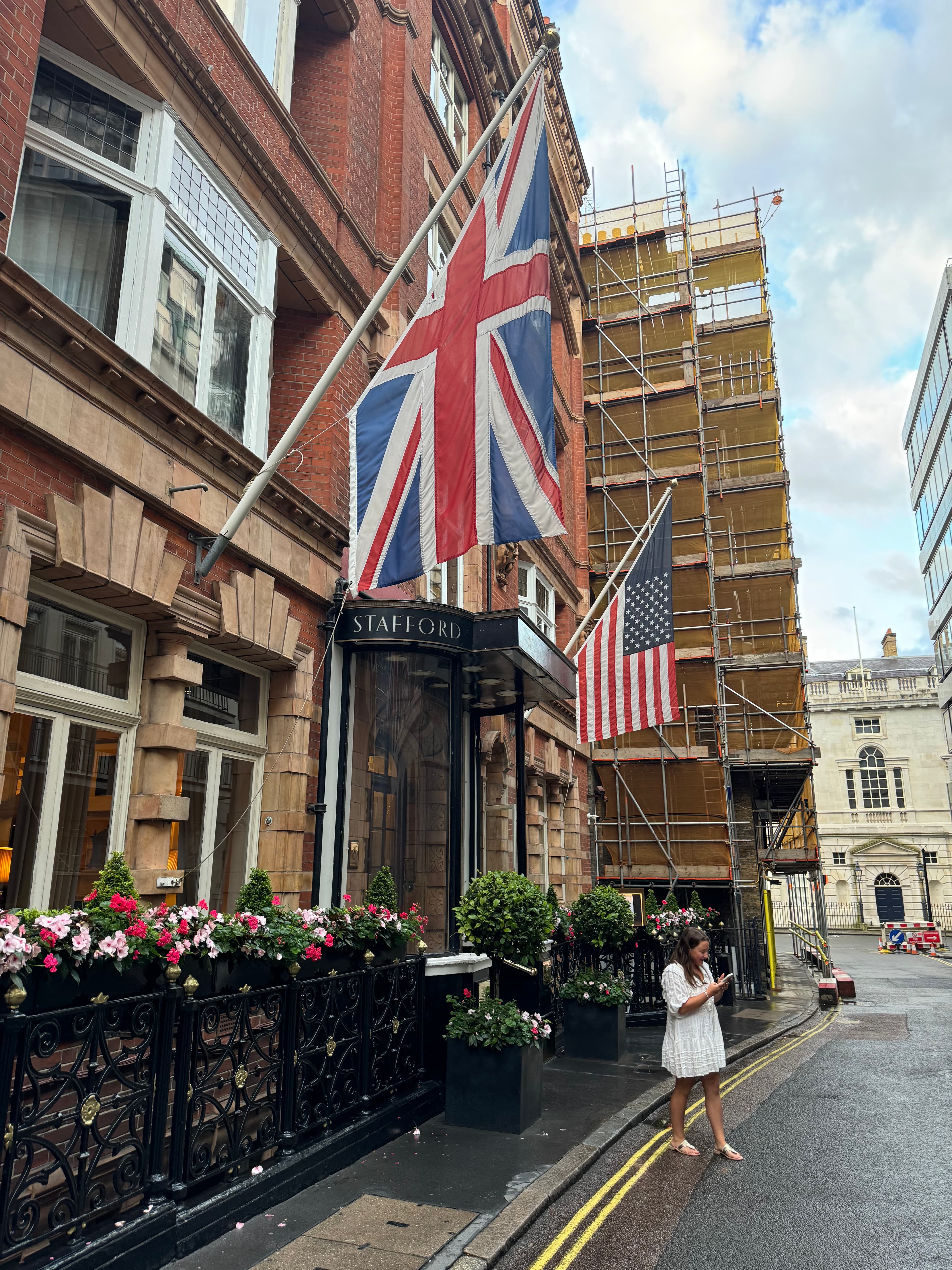Brick building adorned by a British flag during the daytime.