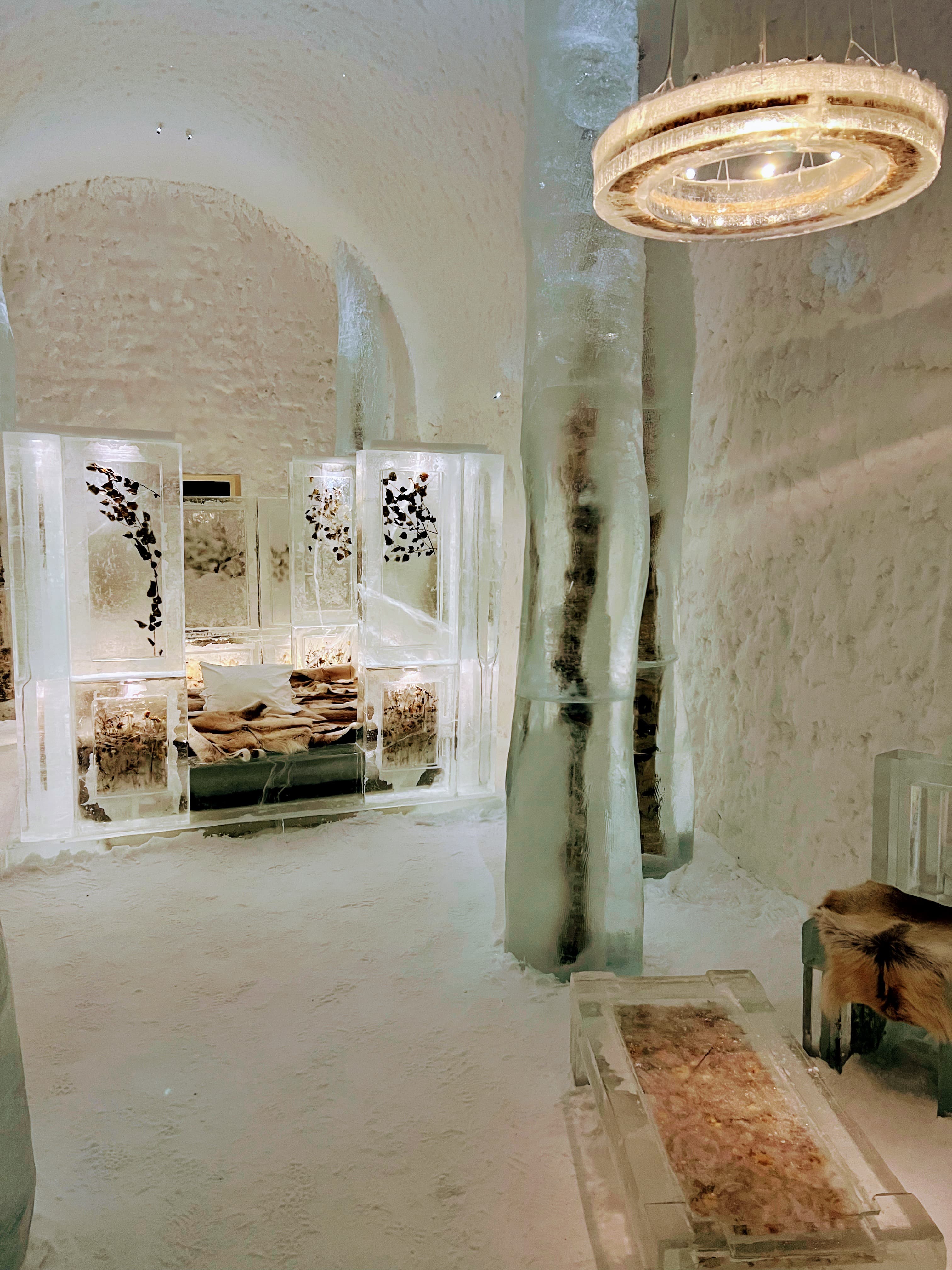 Interior view of a white room with modern circular chandelier and furniture