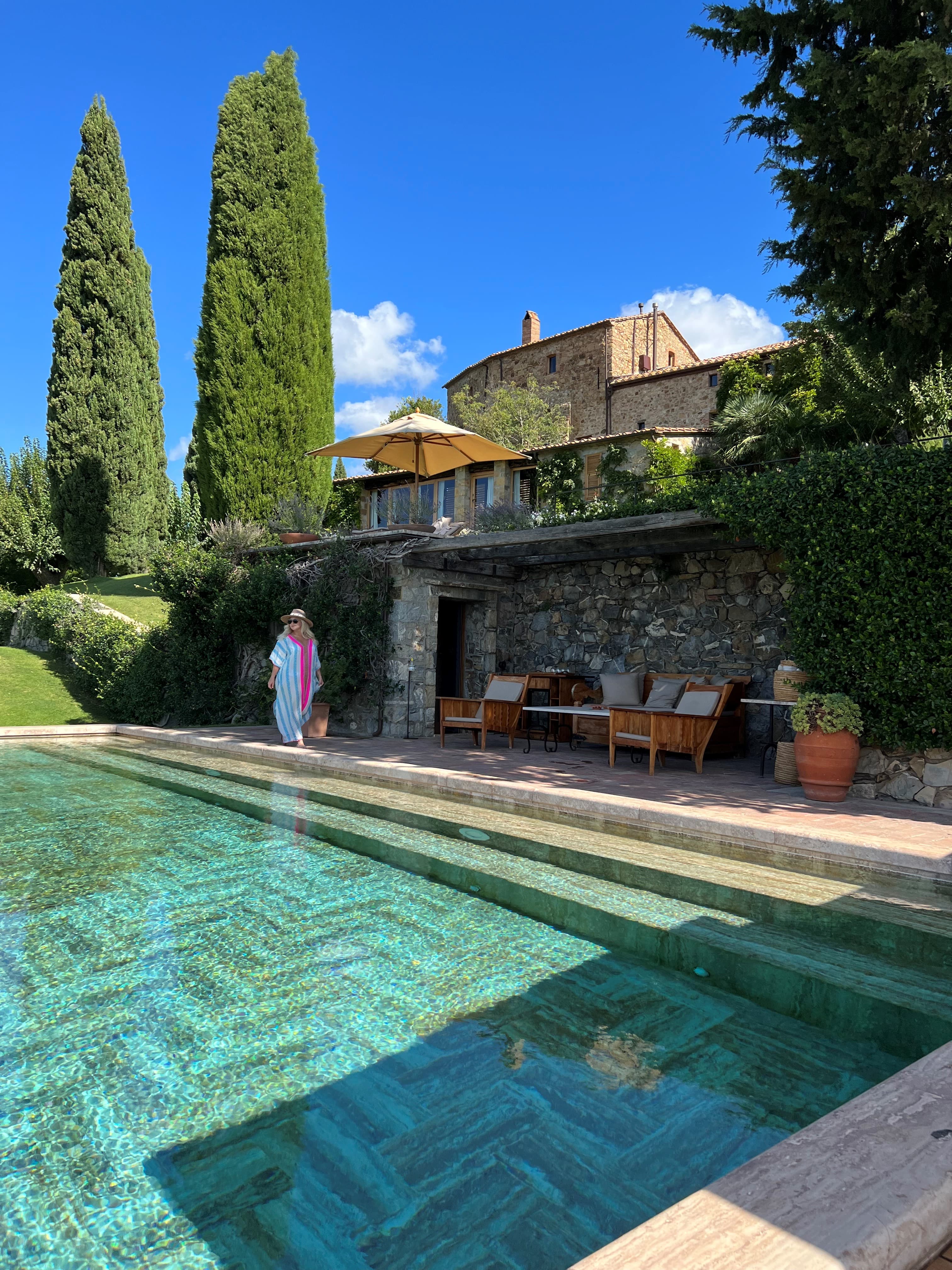 Empty resort pool with furniture in the shade to one side on a sunny day