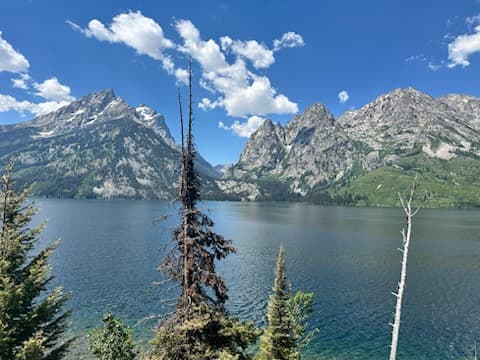 View of a glacial lake and surrounding mountains on a sunny day