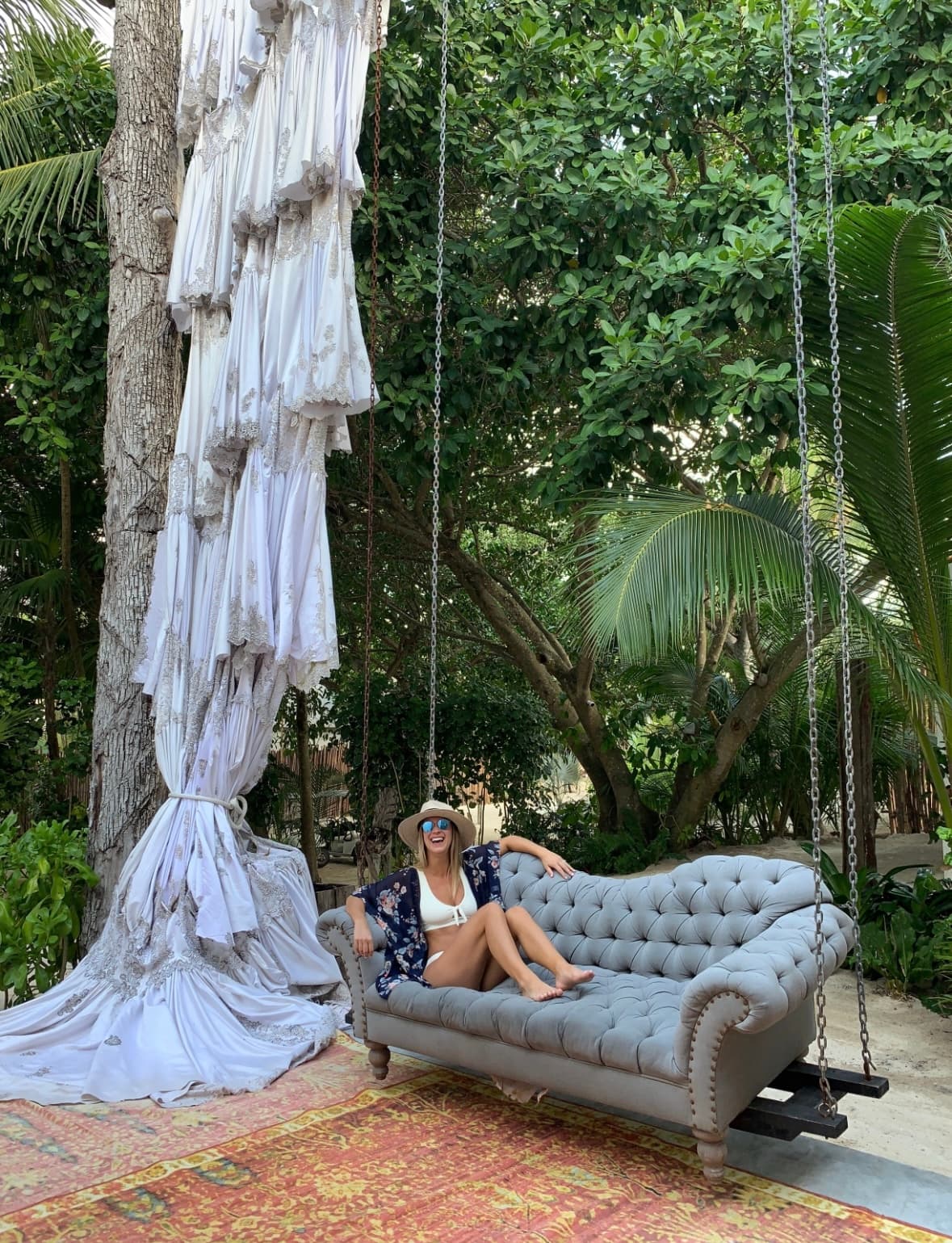 Meagan posing on a couch outdoors in nature.