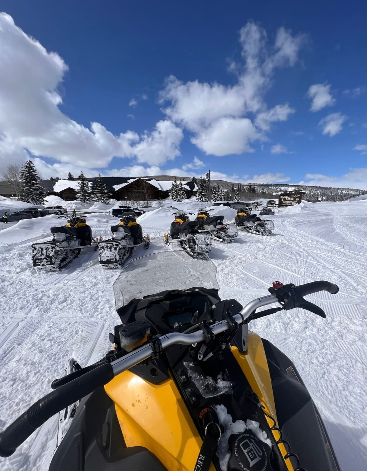 View of the outdoors while the ground is covered in snow during the daytime with snow bikes.