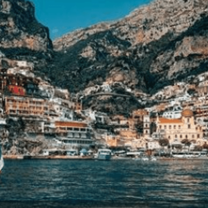 A picturesque coastal town with colorful buildings on a steep hill overlooking the sea.