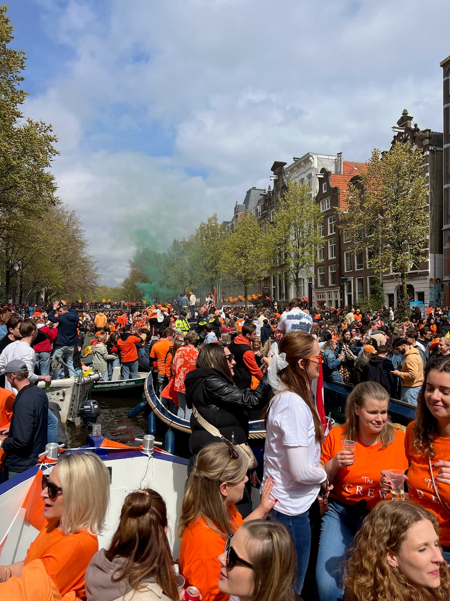 A canal full of boats and large groups of people during the daytime