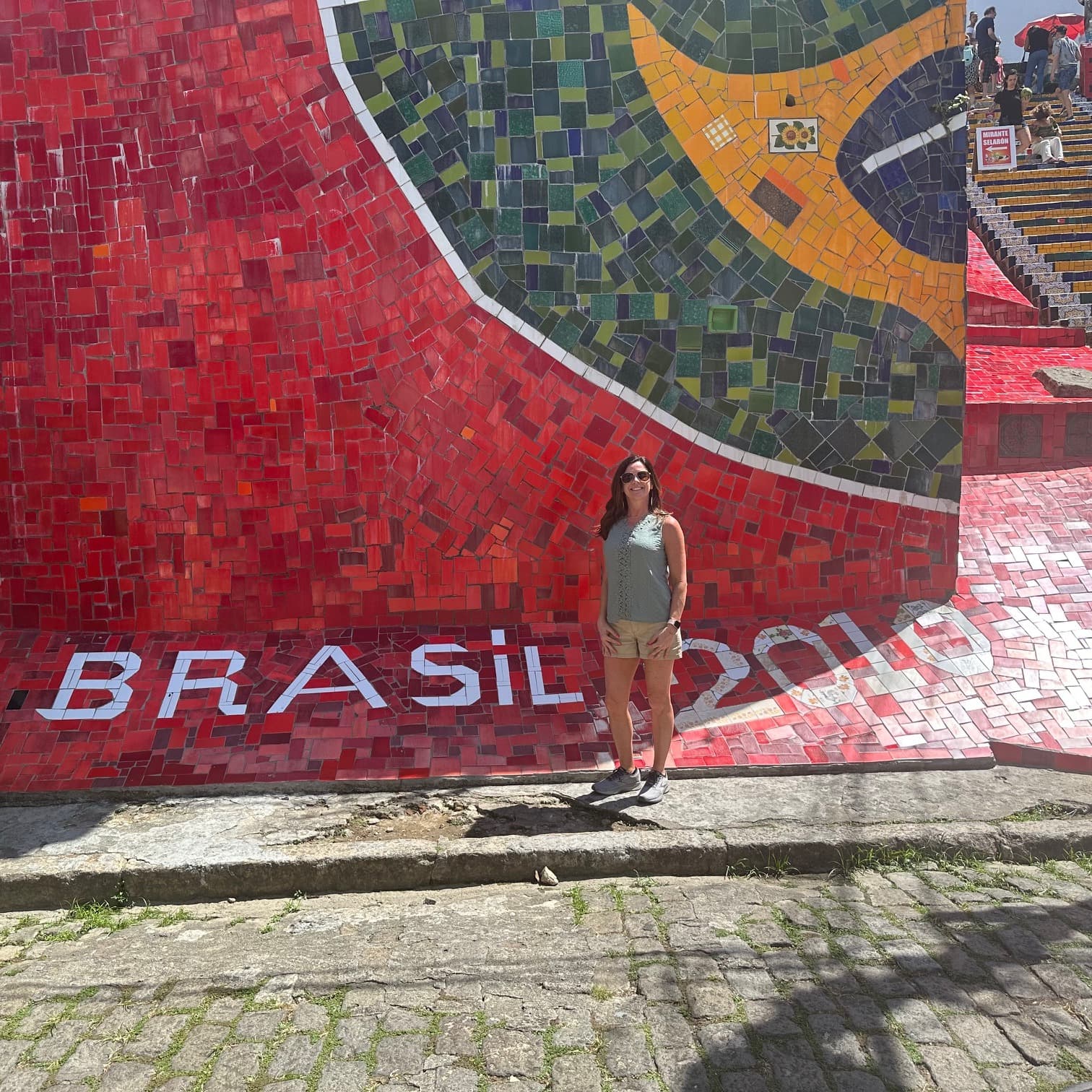 A woman standing in front of red painted wall with Brazil 2010 written on it.