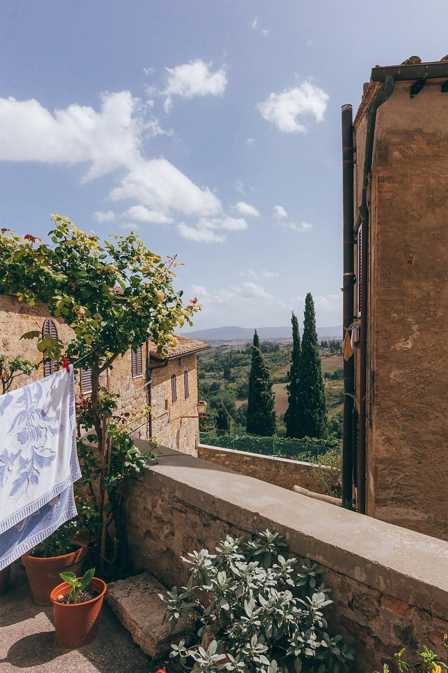 Rustic balcony of Siena in Italy's lush Tuscan hills on a sunny day.