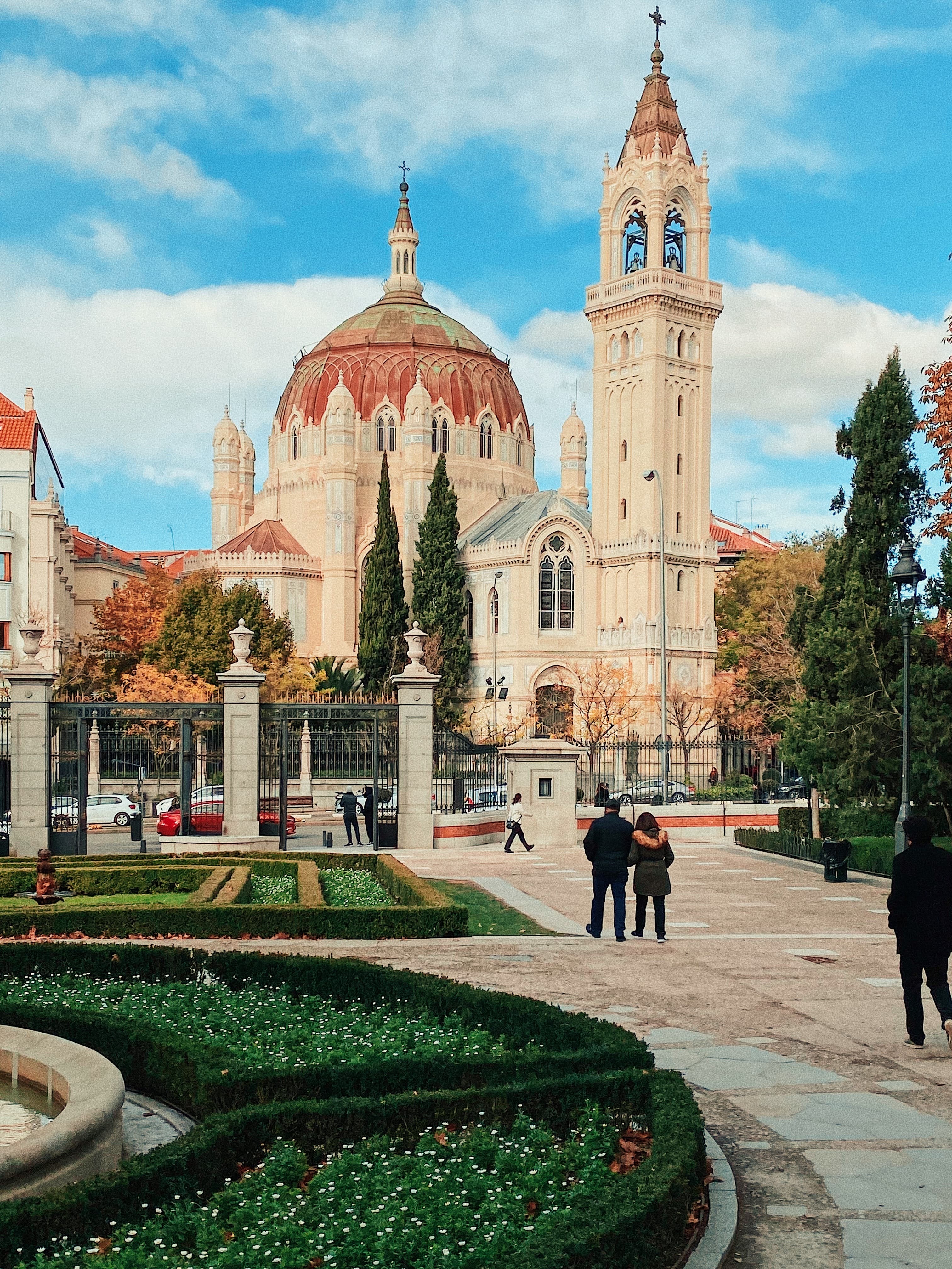 People standing next to gardens and building during daytime