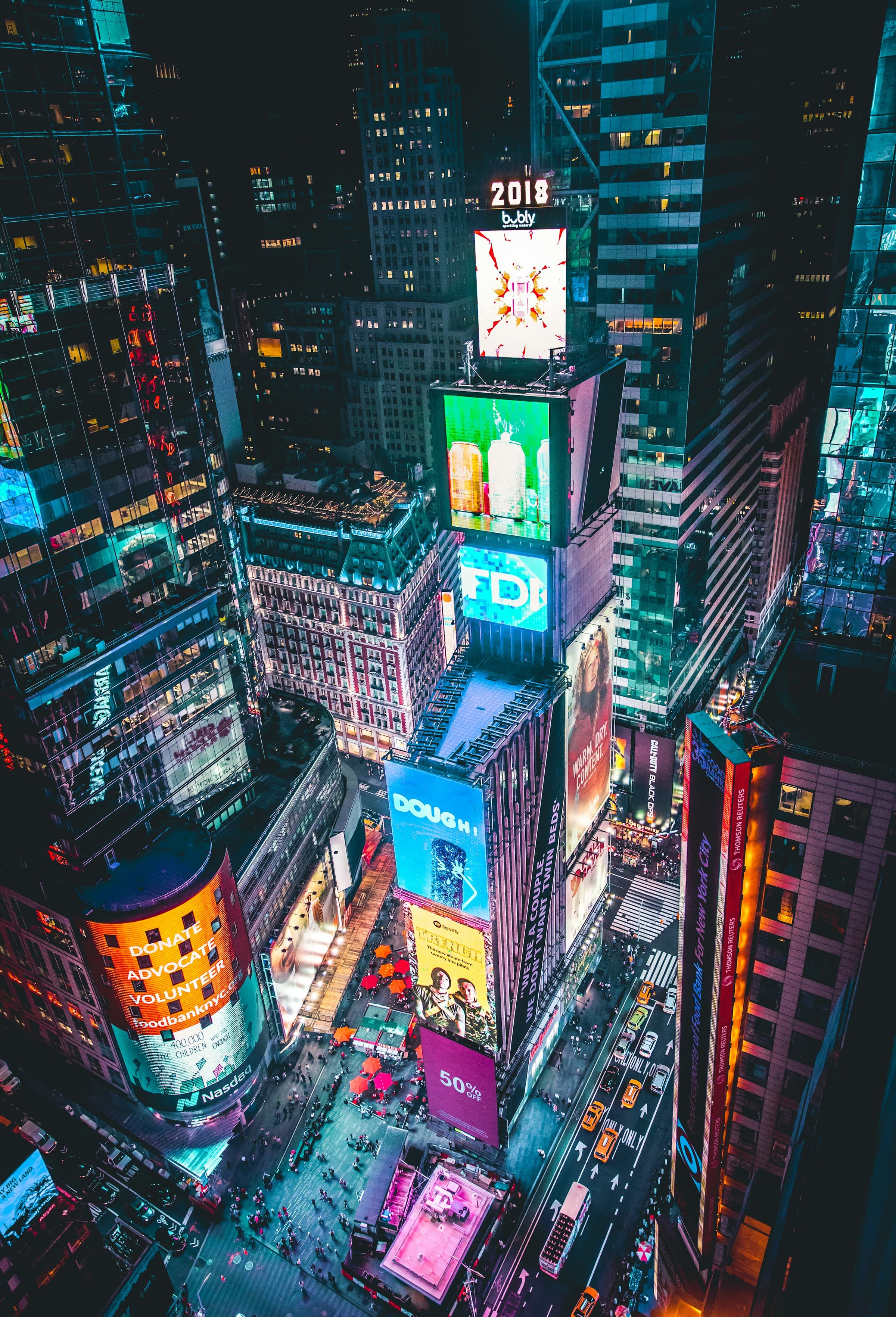 A aerial view of the city buildings of New York City taken from above at nighttime