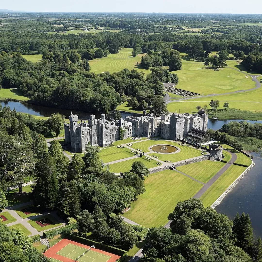 Aerial view of a grey castle surrounded by garden.