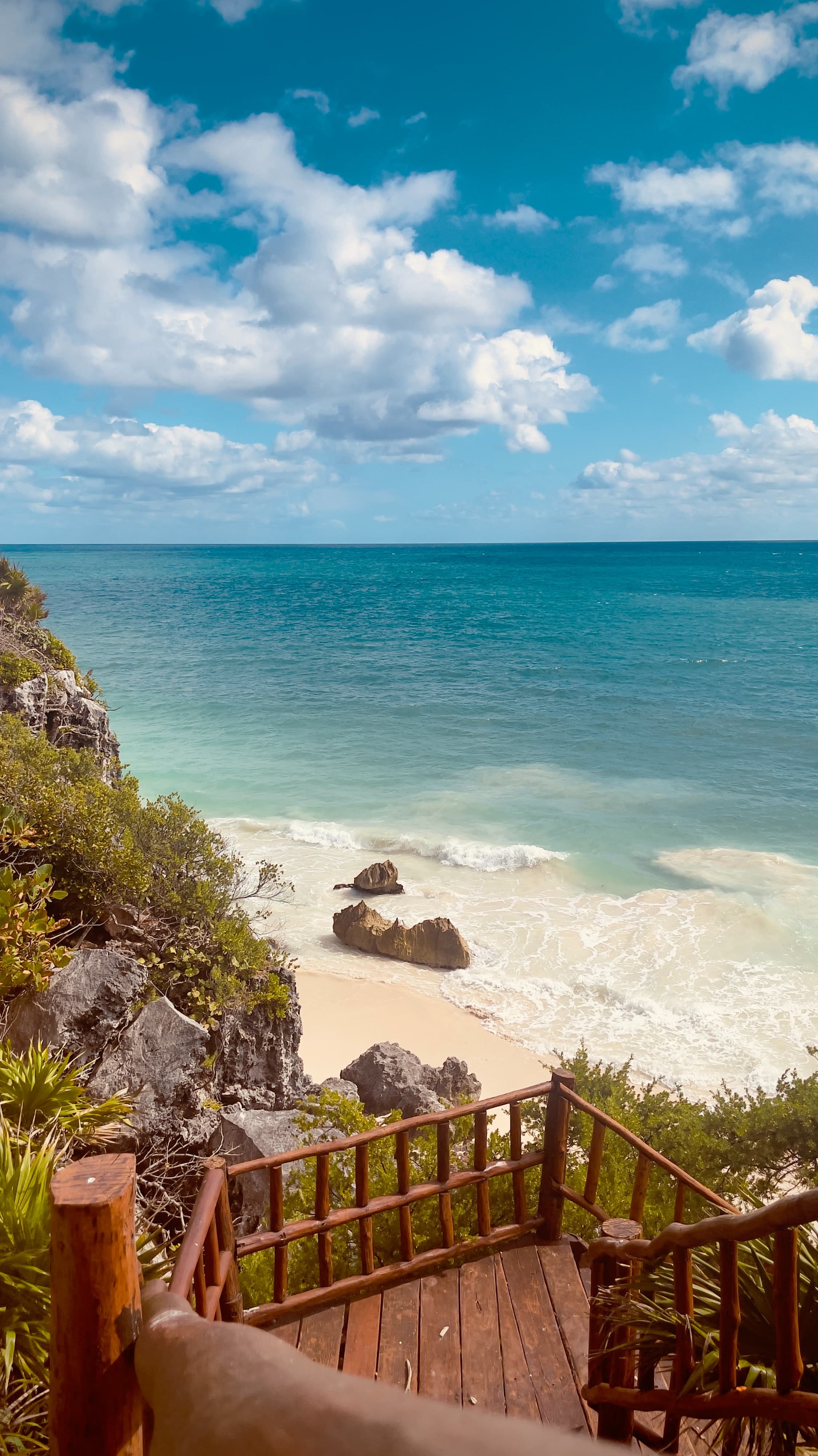 stairs leading down to the beach with ocean in the background