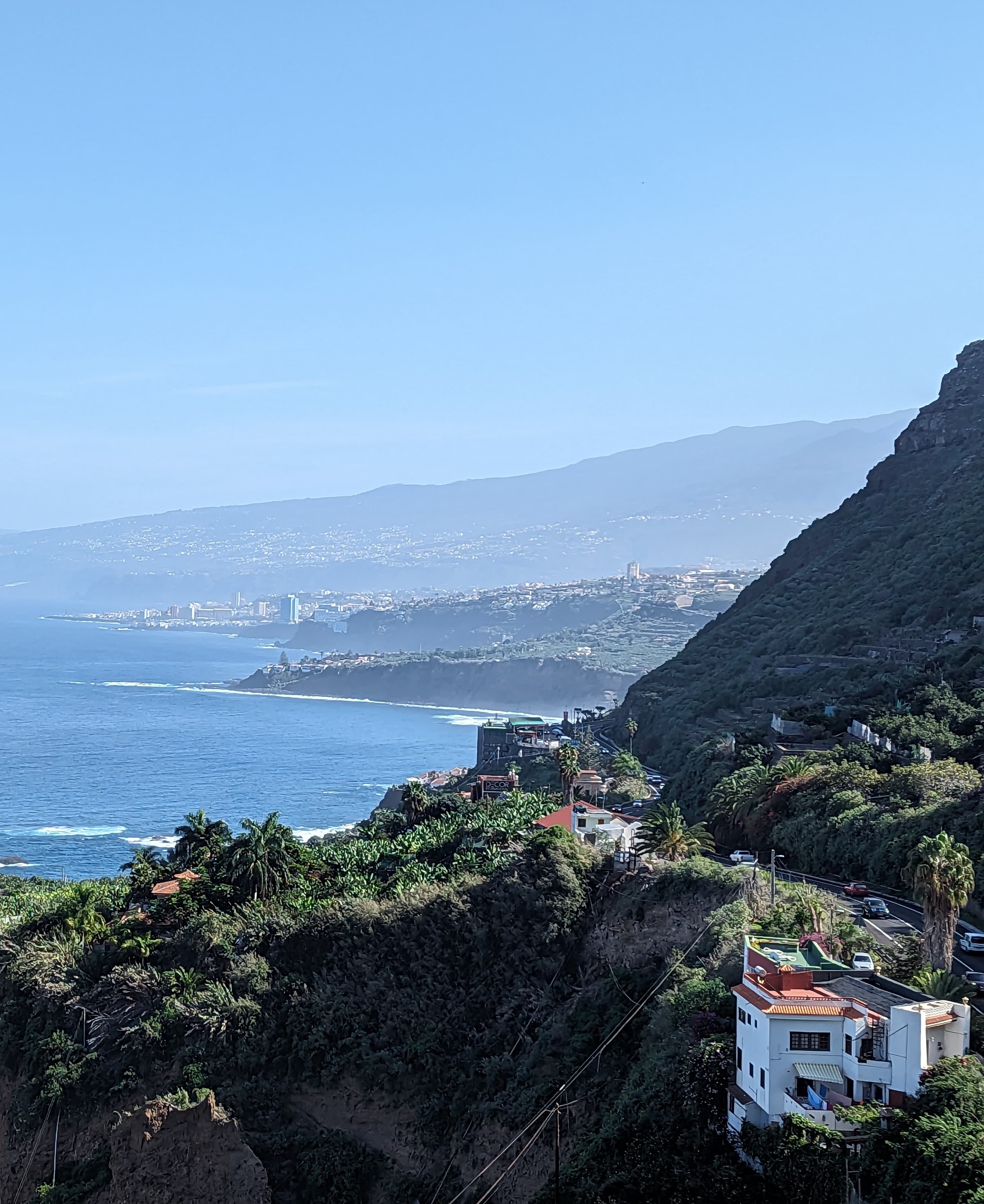 View of Tenerife Coast with buildings in green hills and the water beyond