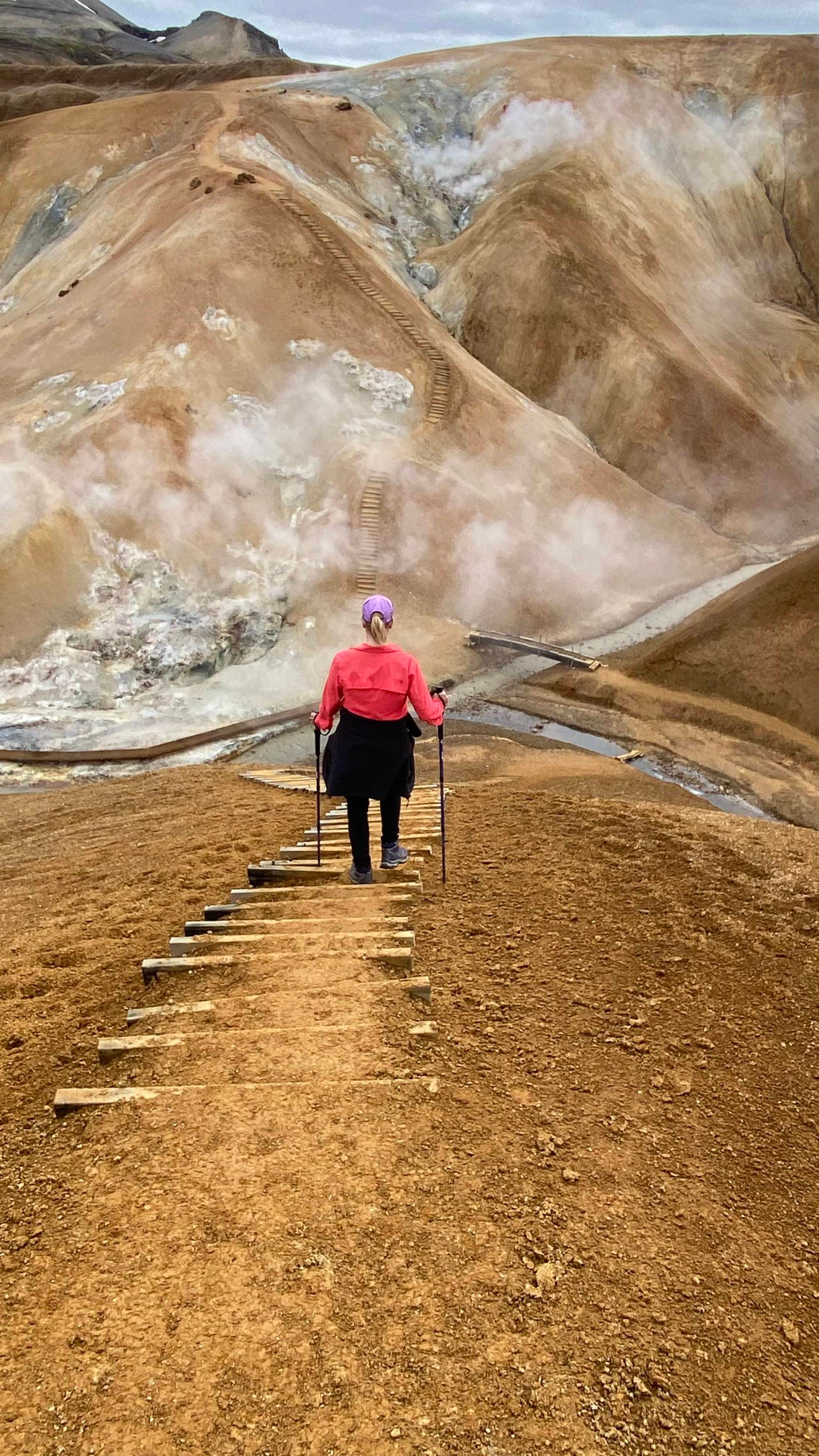 A woman hiking in peach shirt.