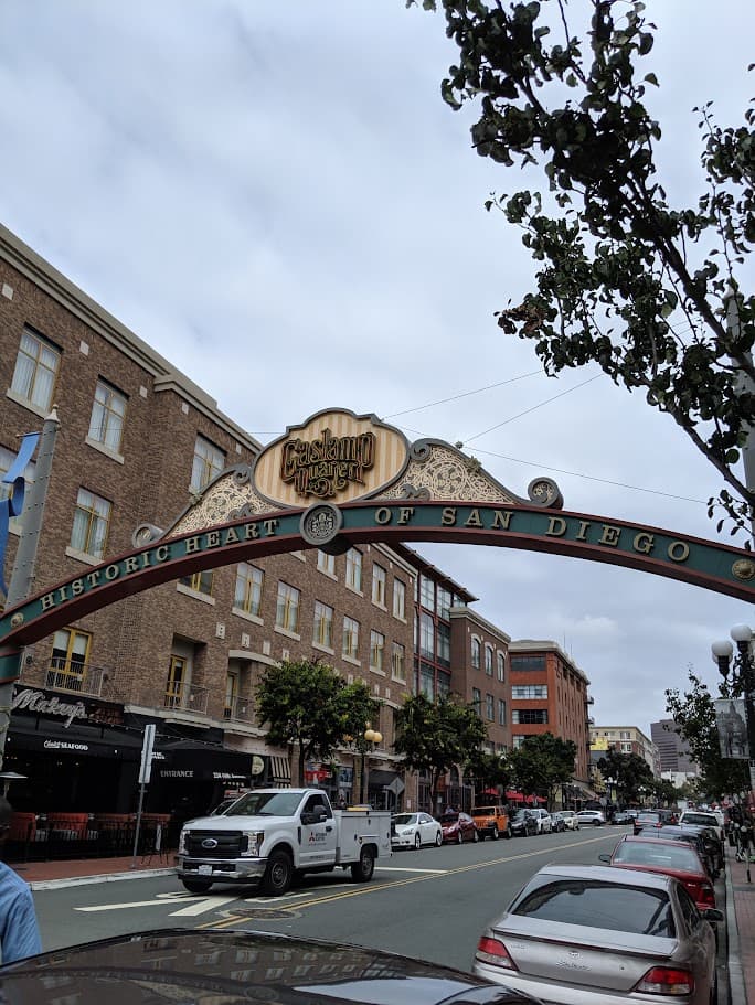 Gaslamp Quarter in Downtown San Diego is a vegan haven. Picture is of a street with cars and a "Gaslamp" arch over the center.