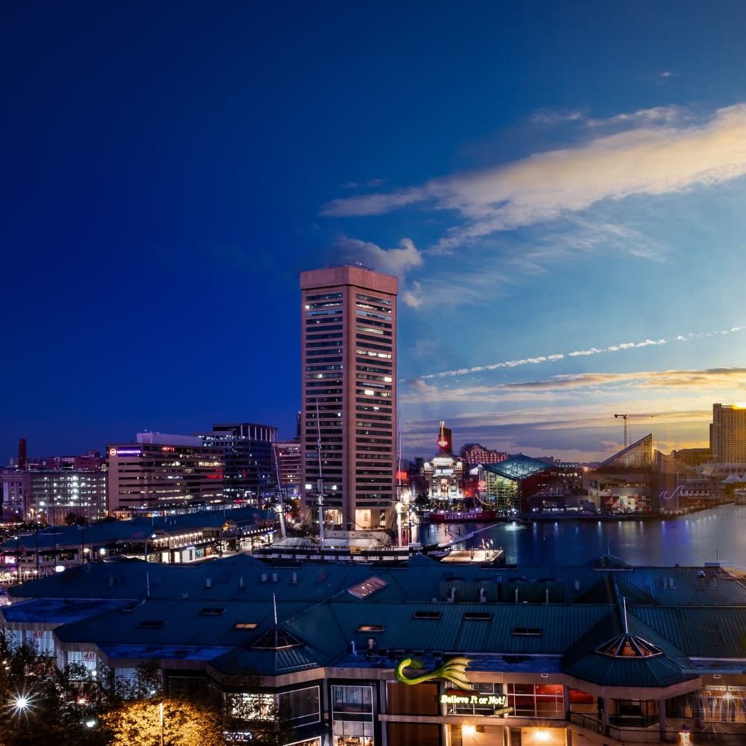 Day to night view of a city harbor.