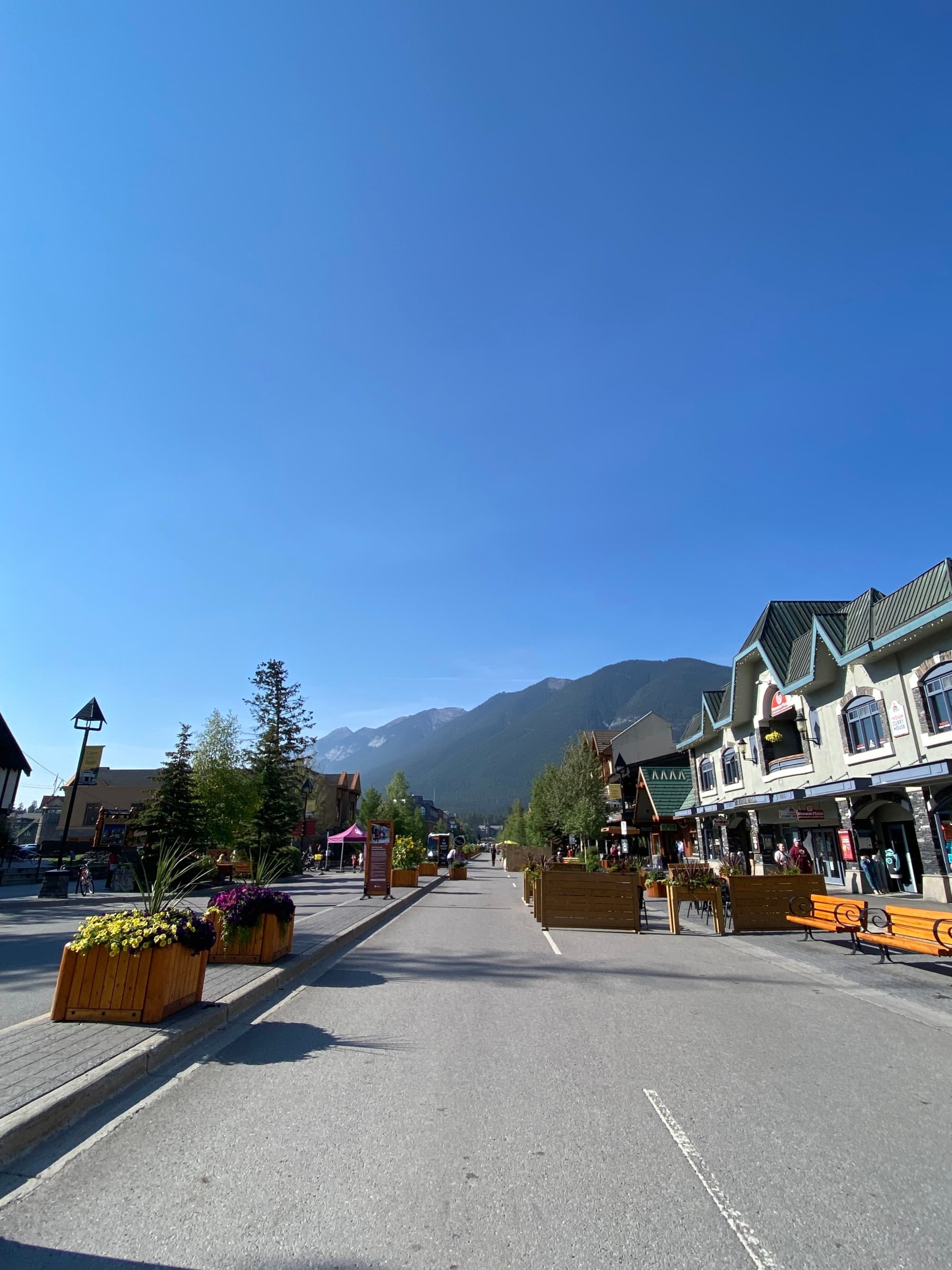 A road with mountains at the back on a sunny day.