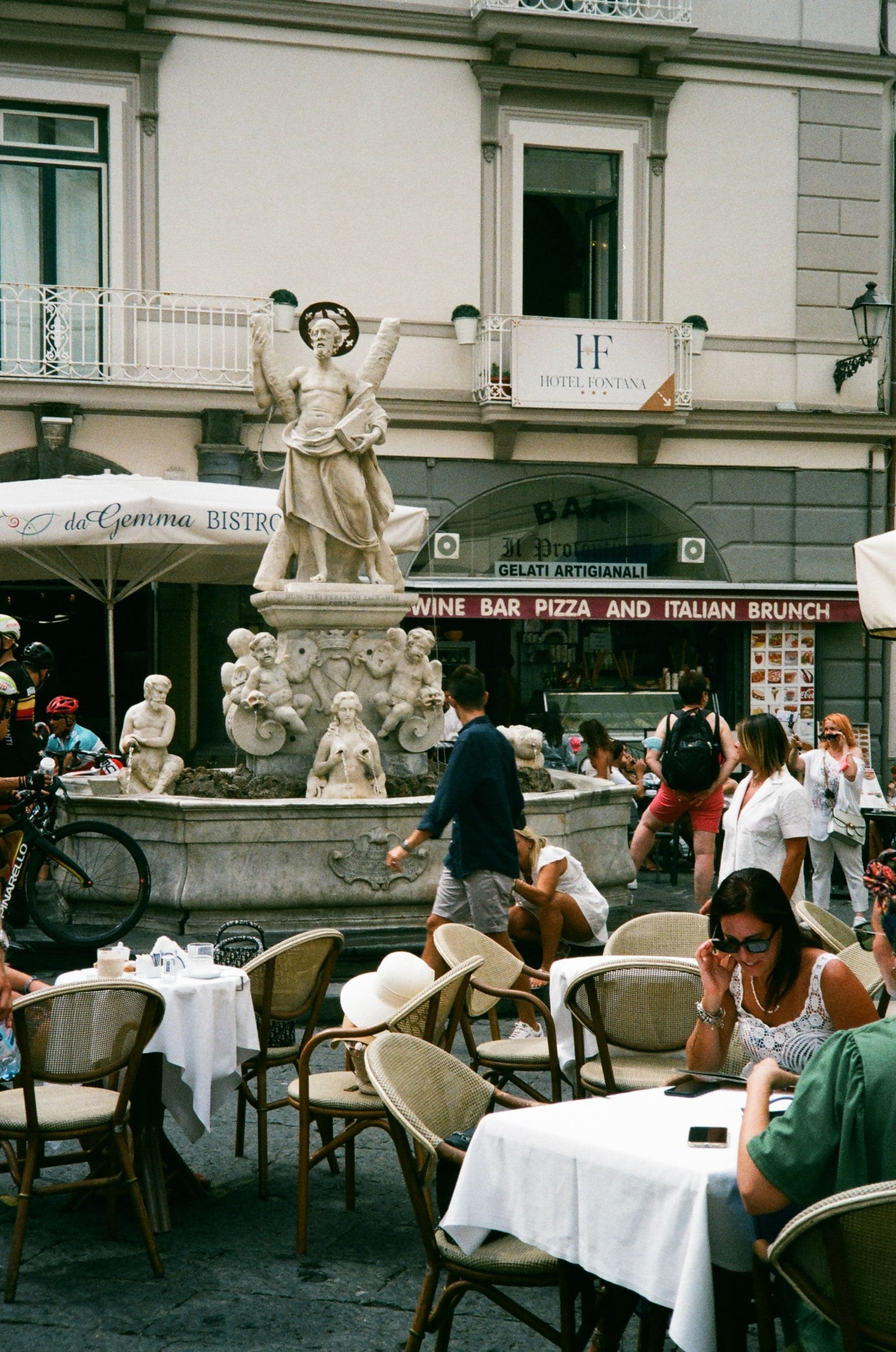 A group of people sitting on table in front of a fountain