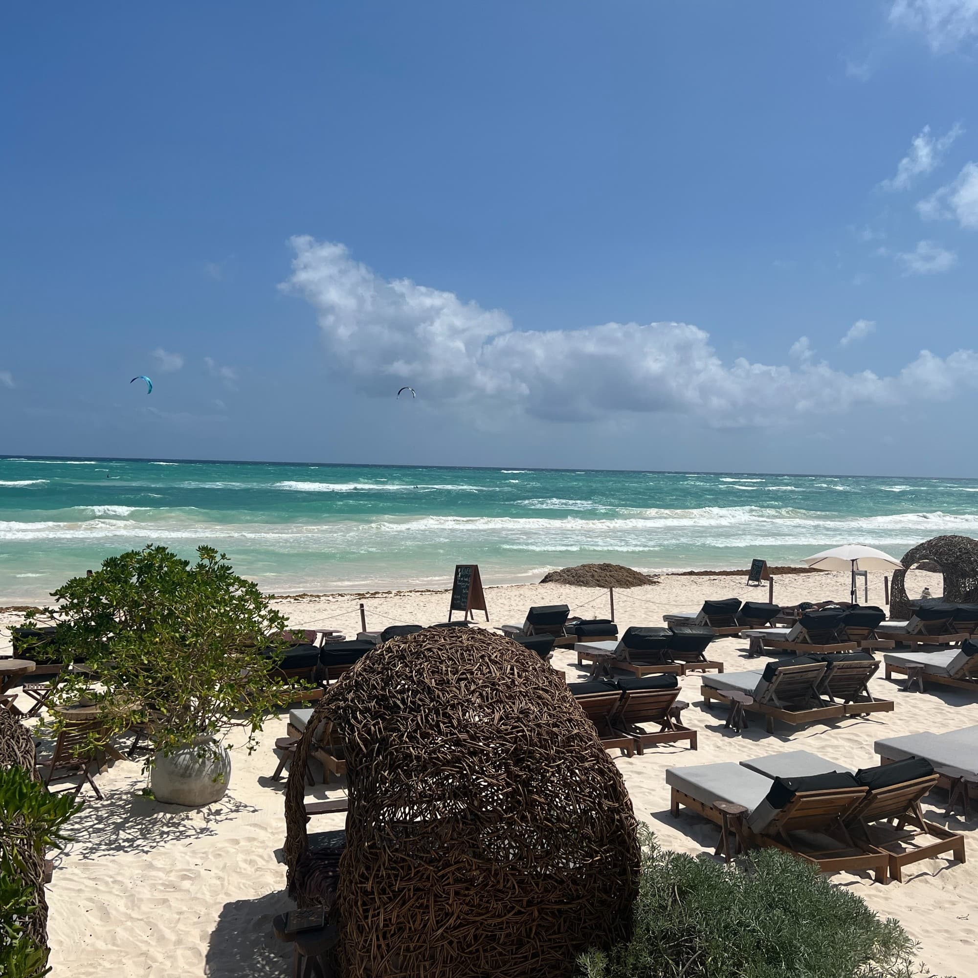 Tulum beach with lounge chairs at front.
