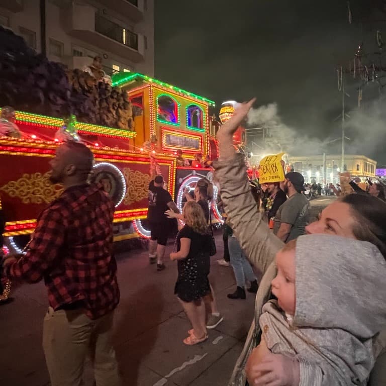 People and kids dancing in a festival at night.