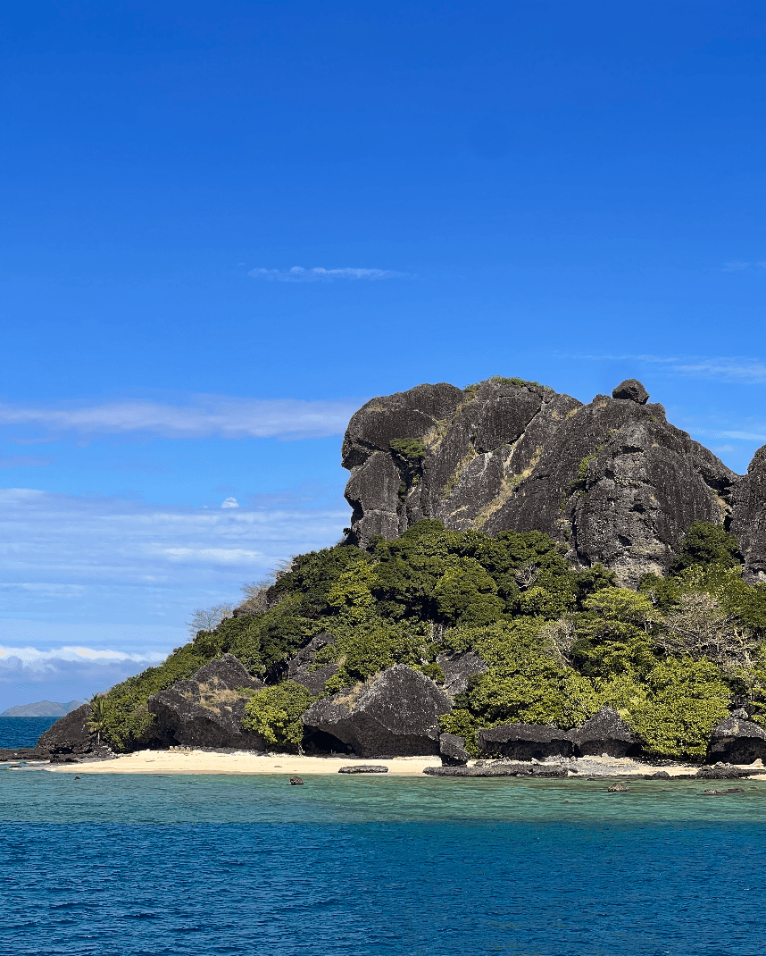 An ocean with a rocky hill on an island.