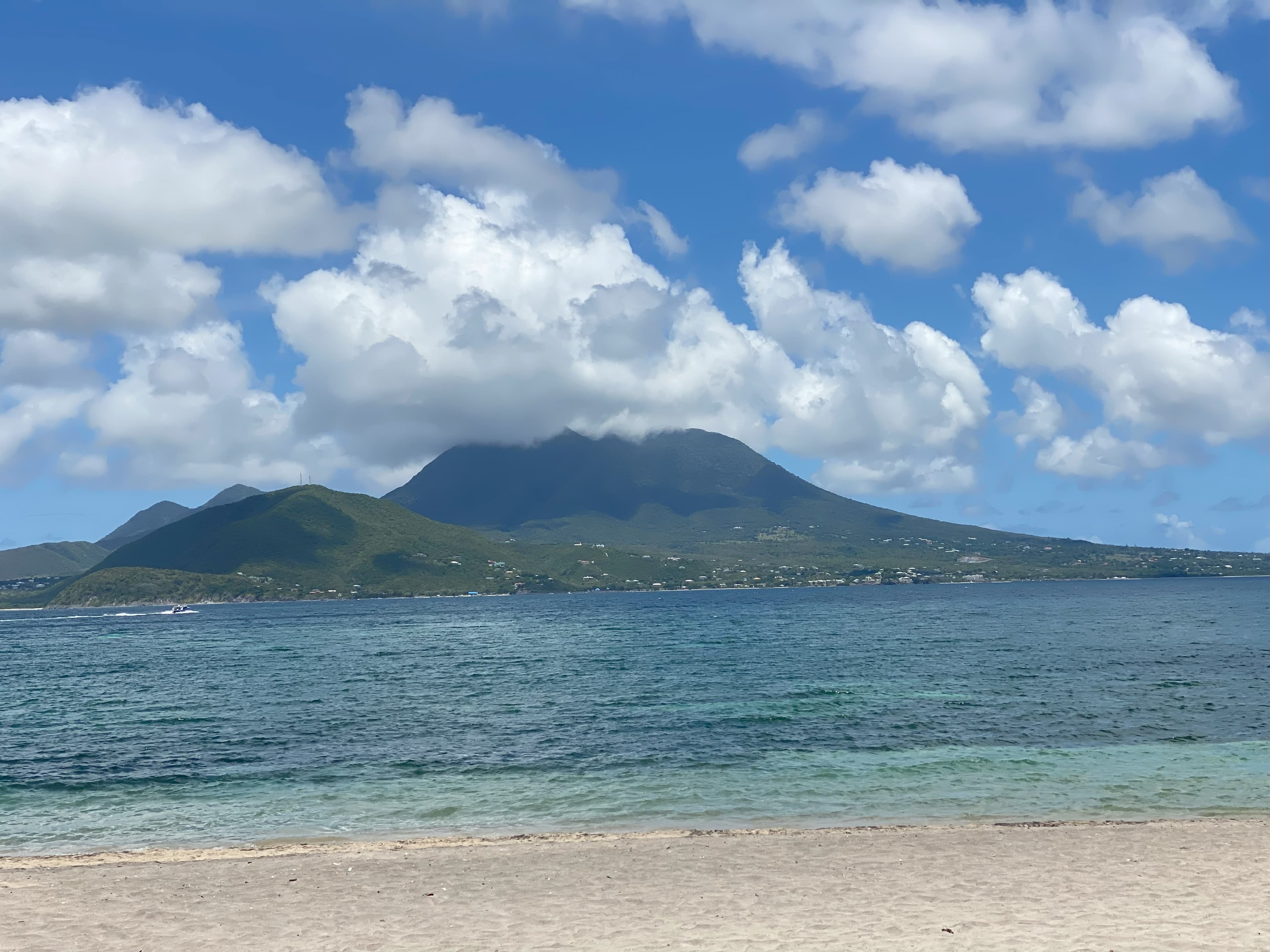 View from the beach of a mountain in the distance on a cloudy day