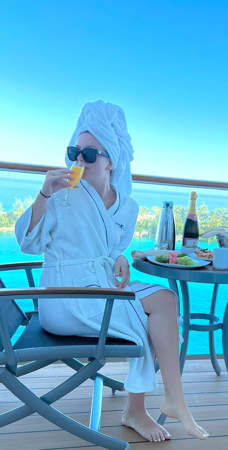 woman in a robe drinking a glass of orange juice