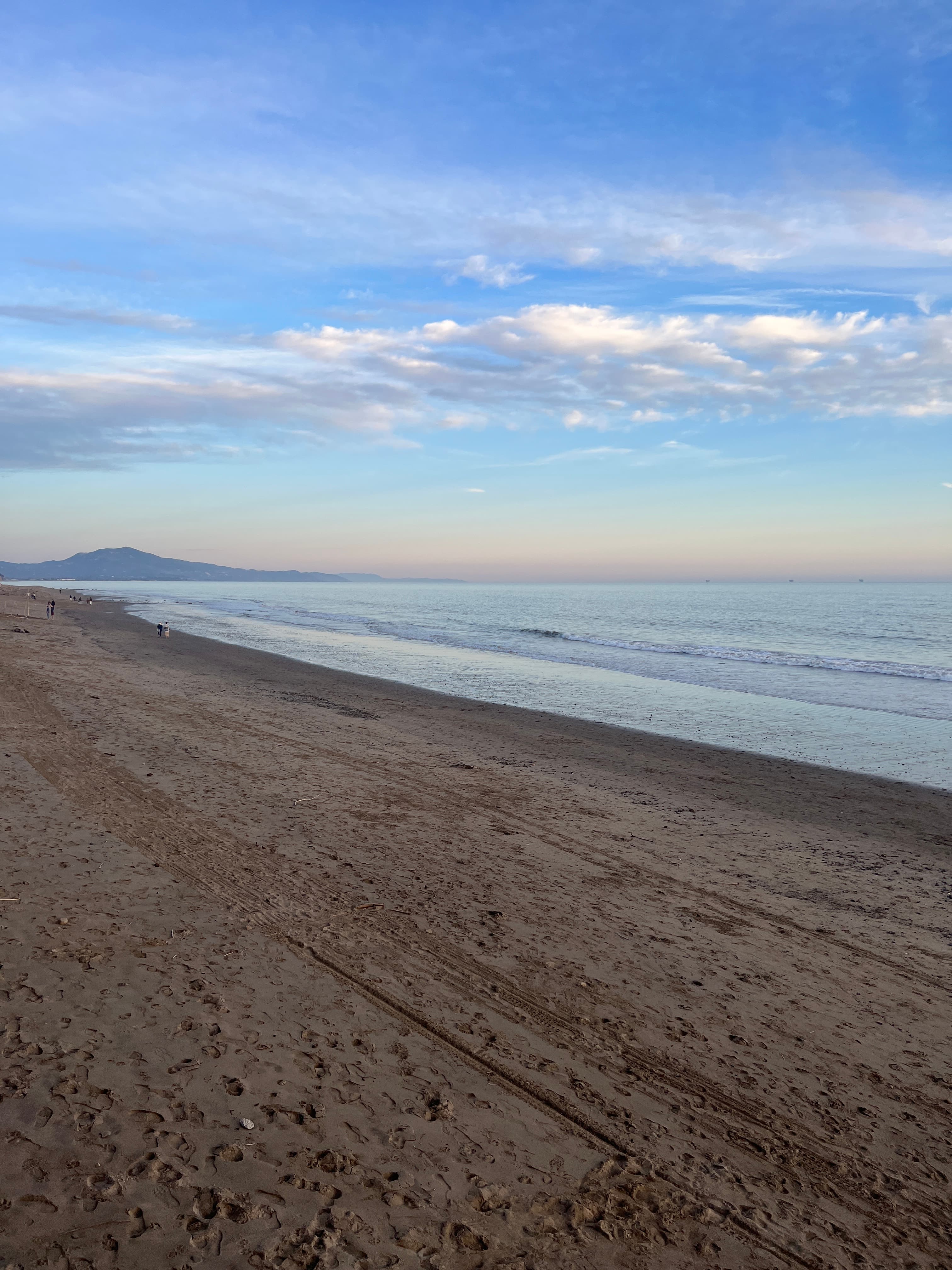 Beach infront of Rosewood Hotel with a lovely shoreline and clouds in the distance.