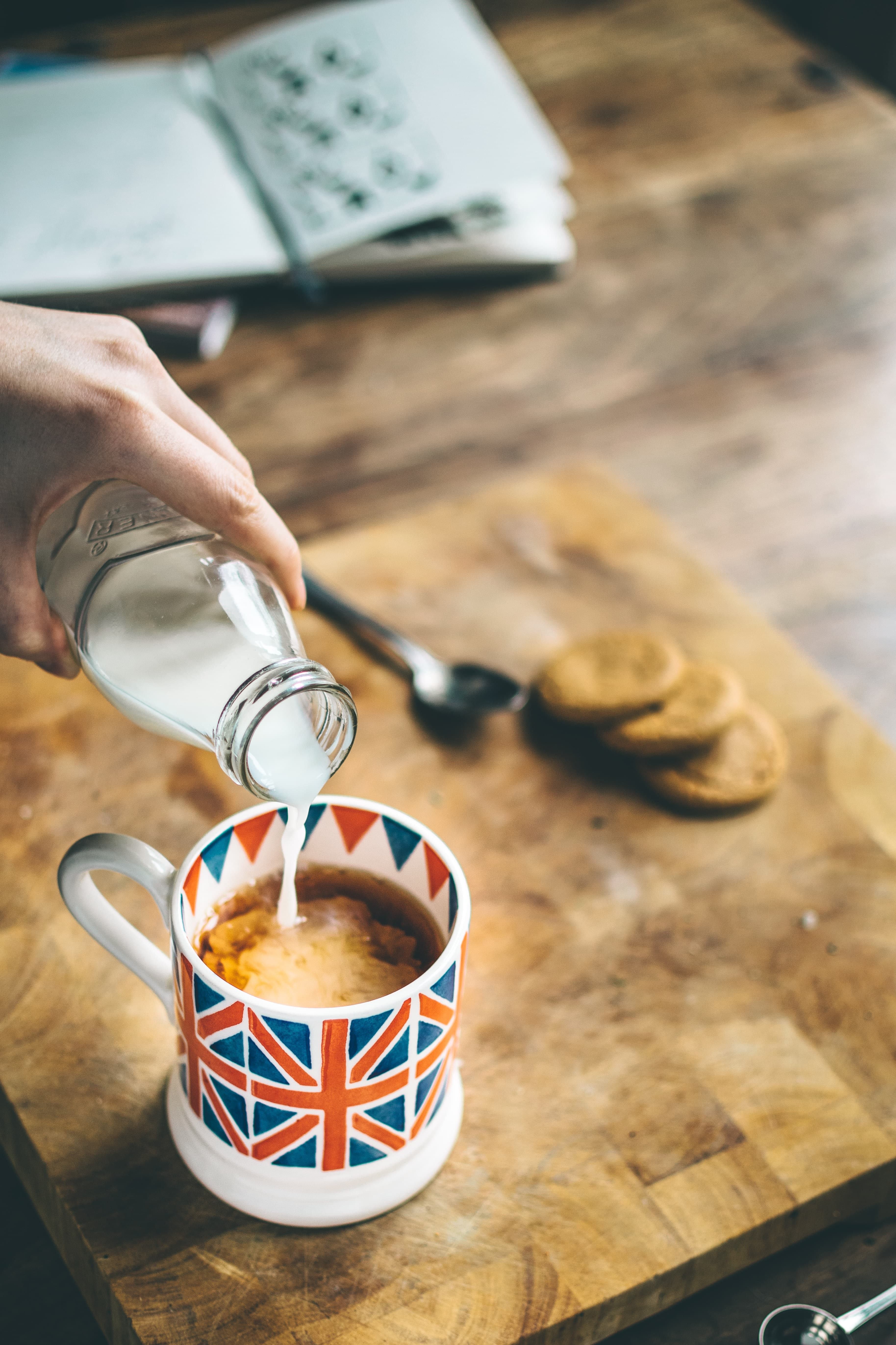 A cup with the British flag on it with black tea and milk.