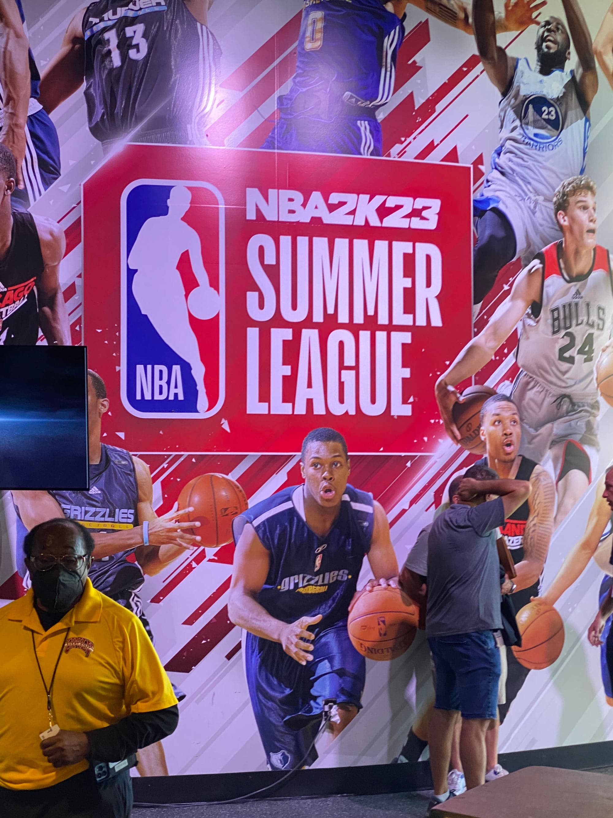 People standing near NBA summer league board.