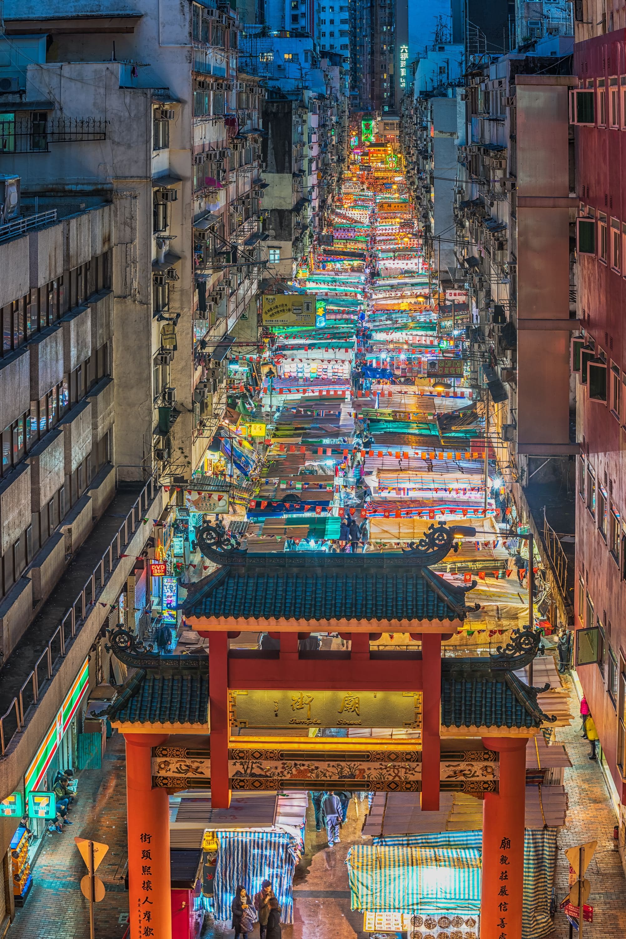a long street of bright lights in a city at a street market