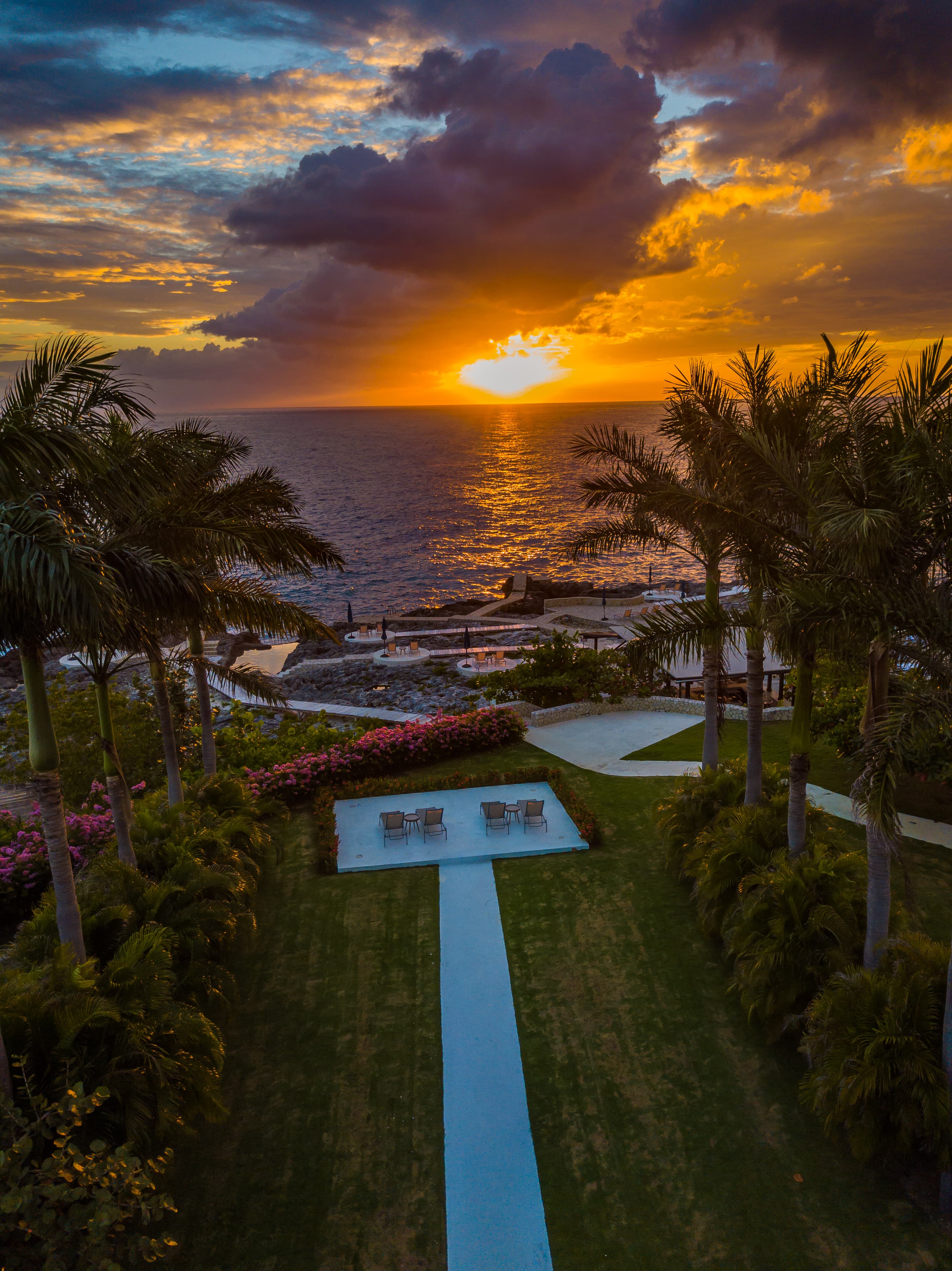 pathway with chairs with ocean in the background during sunset