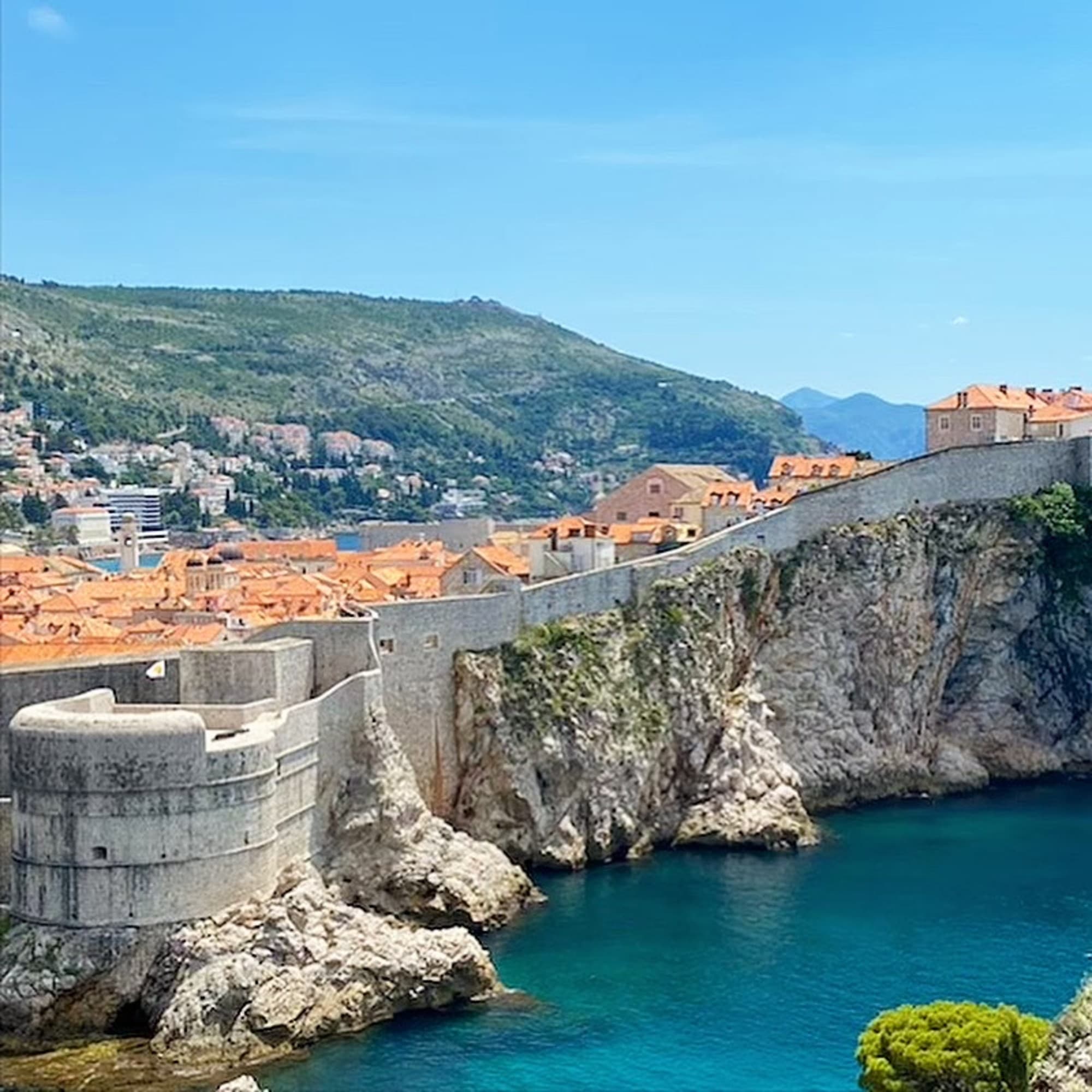 A picture of the City Walls on a mountain near the sea.