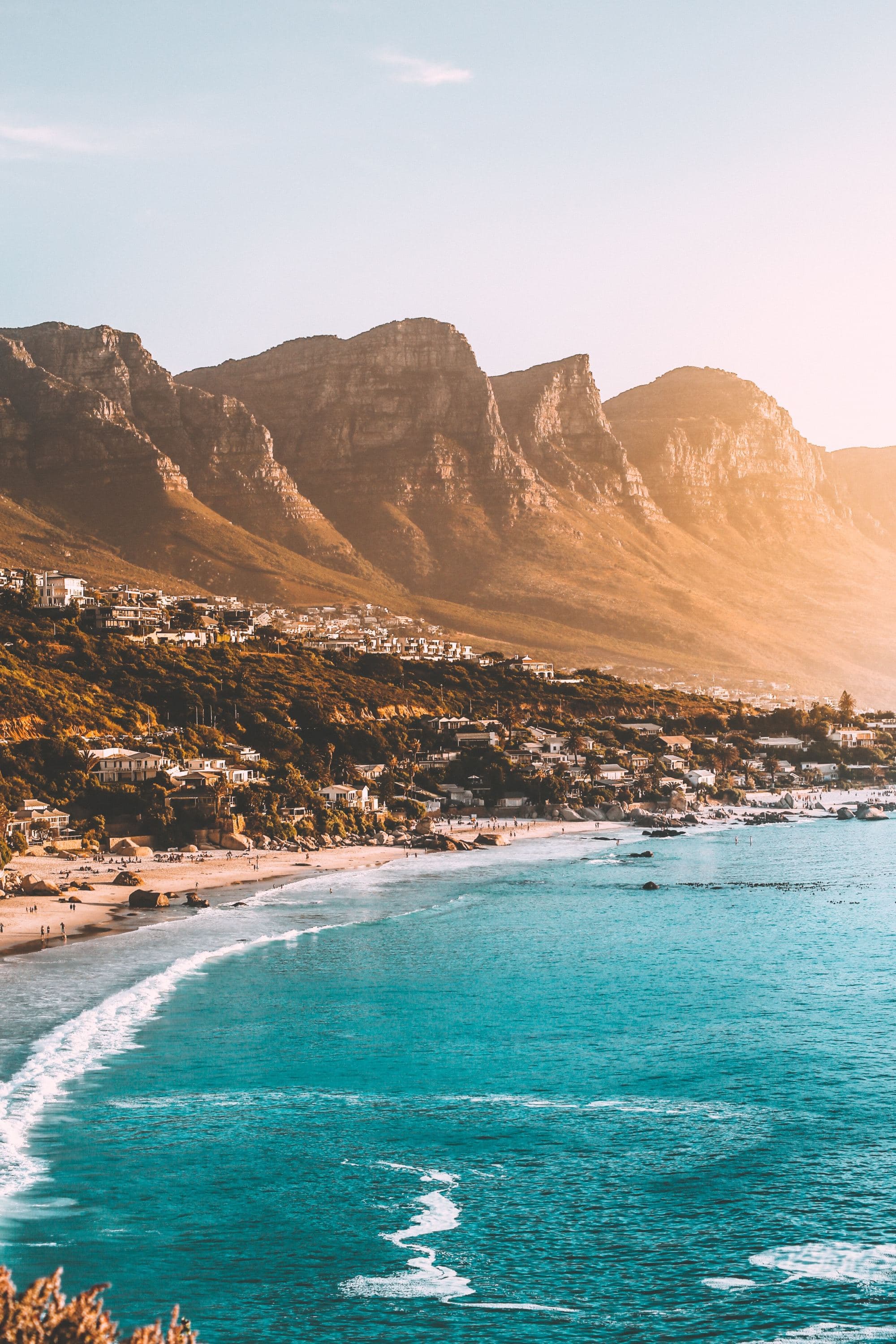 An aerial view of the beach & the mountains during daytime.