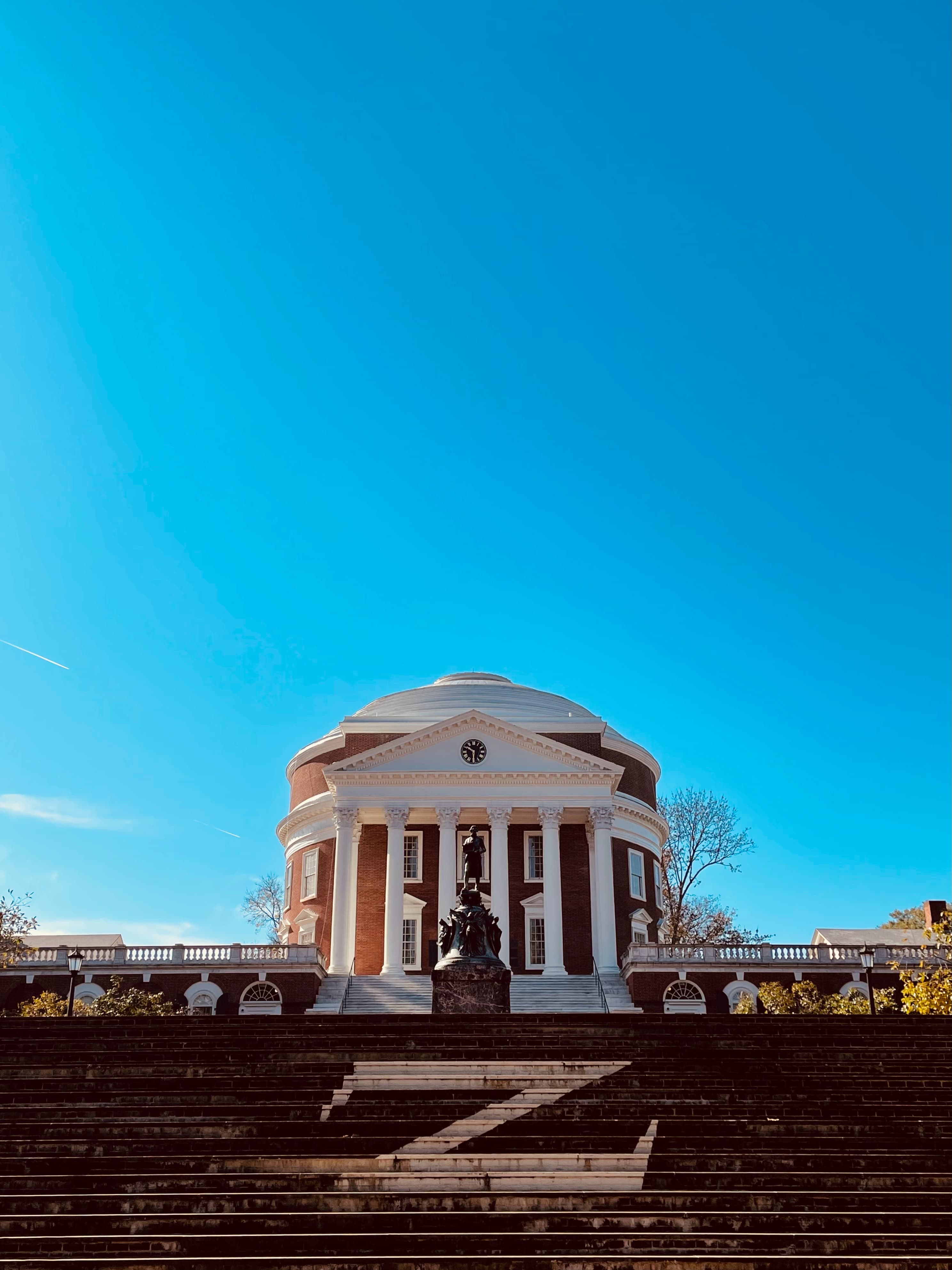 White rotunda with steps under a blue sky during daytime