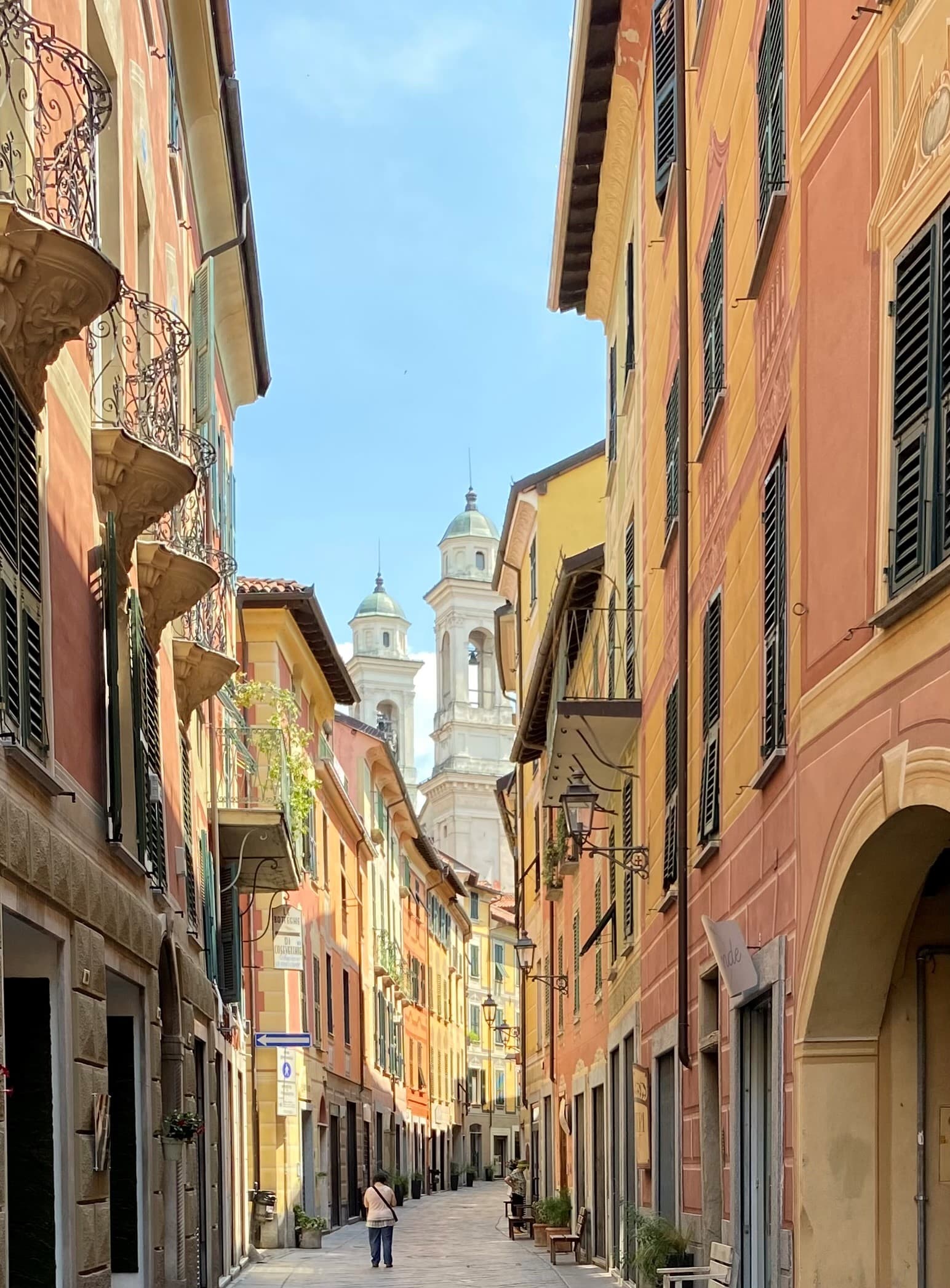 A small street with yellow and orange buildings in Italy.