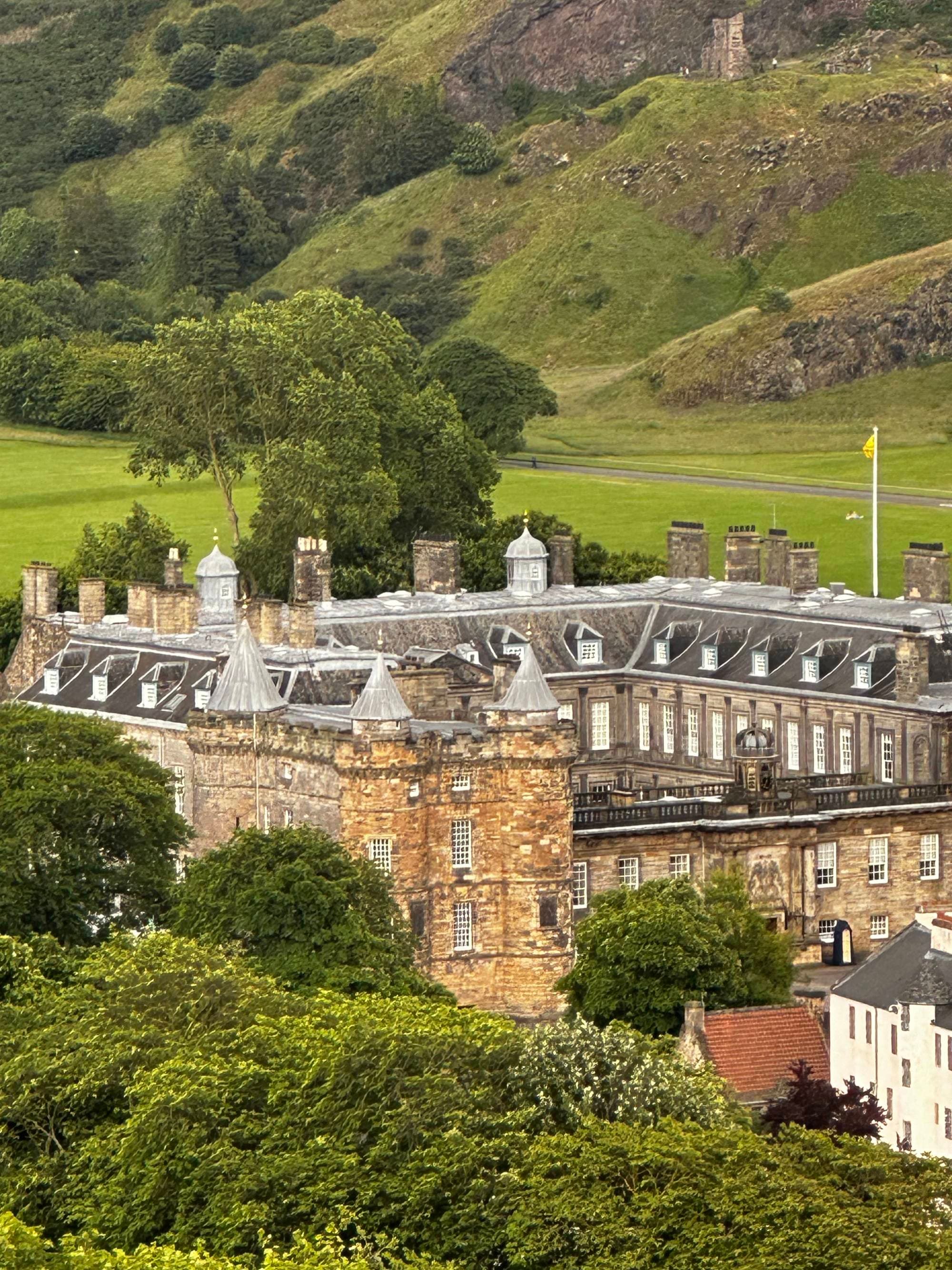 Large castle with green mountains at the back.
