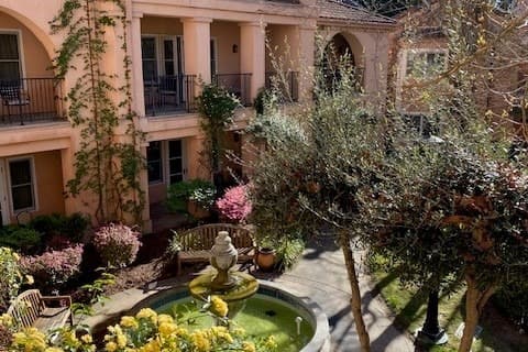 An outside view of the building and the gardens near a water fountain outside Fairmount Sonoma