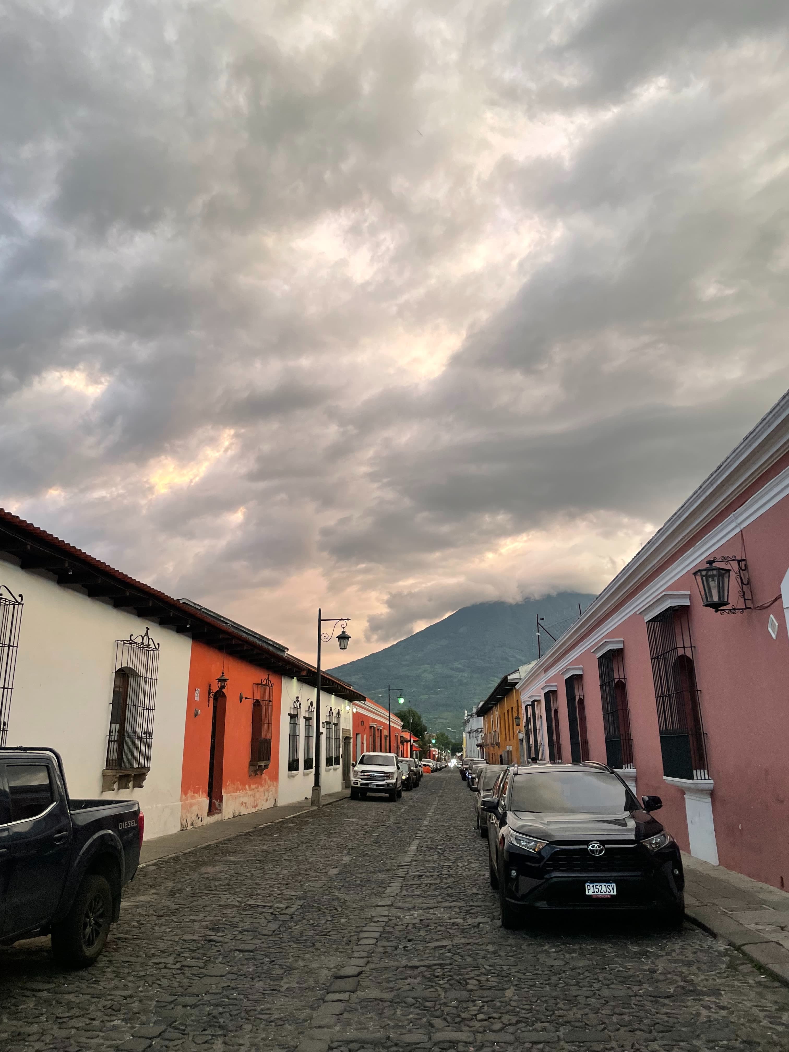 Cars parked on street under cloudy sky
