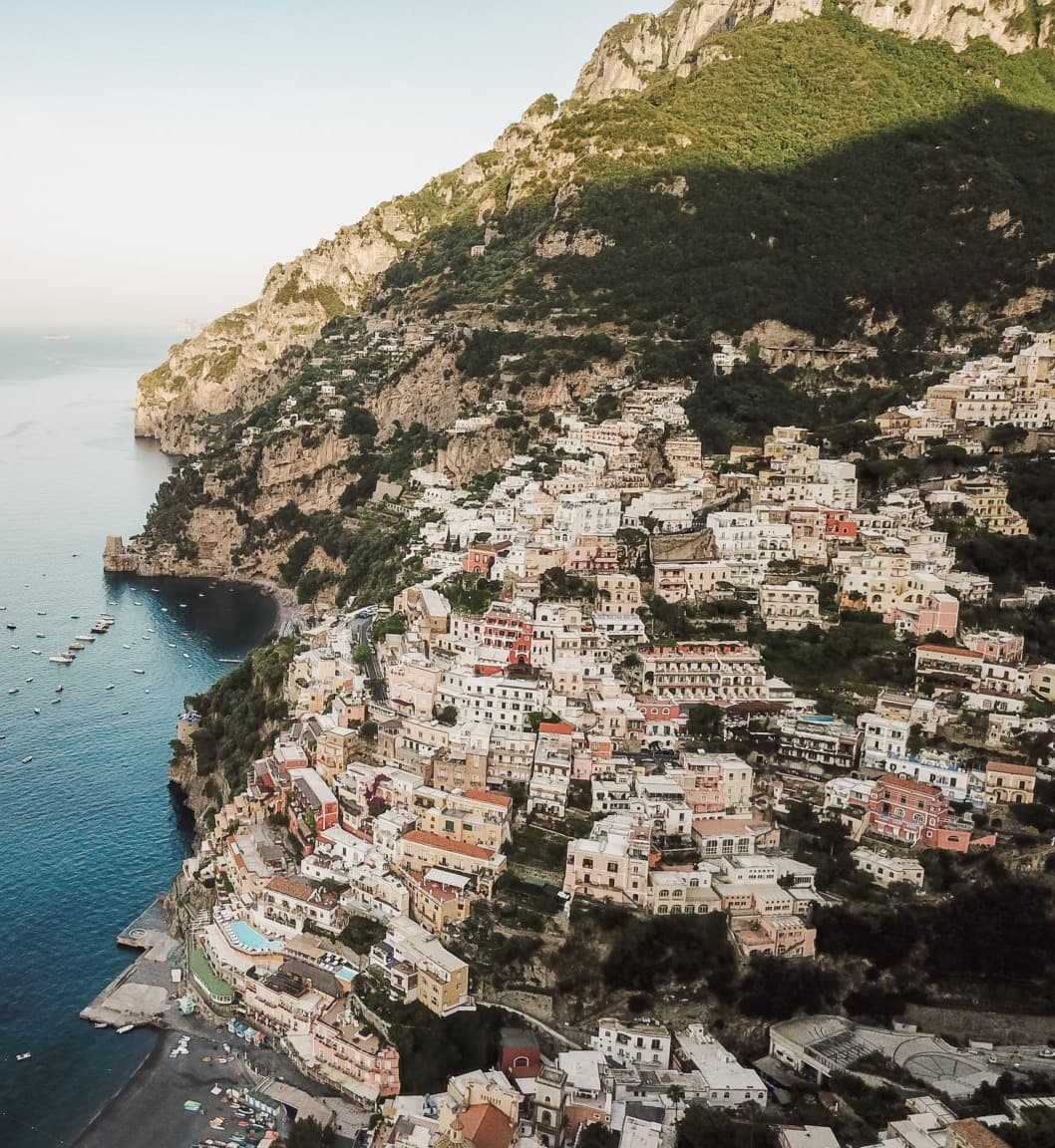 This aerial view shows tiny colorful buildings in the cliffside of Positano.