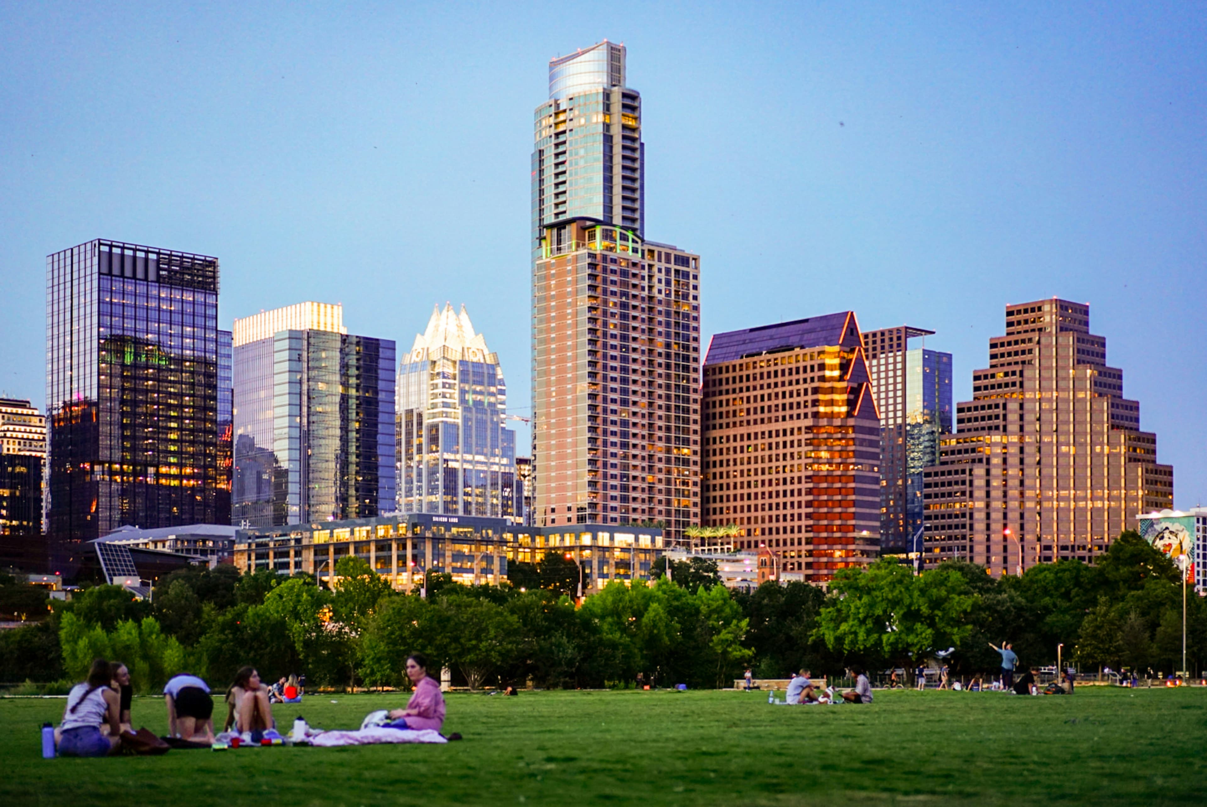 City skyline with a bridge, lake and buildings at sunset.