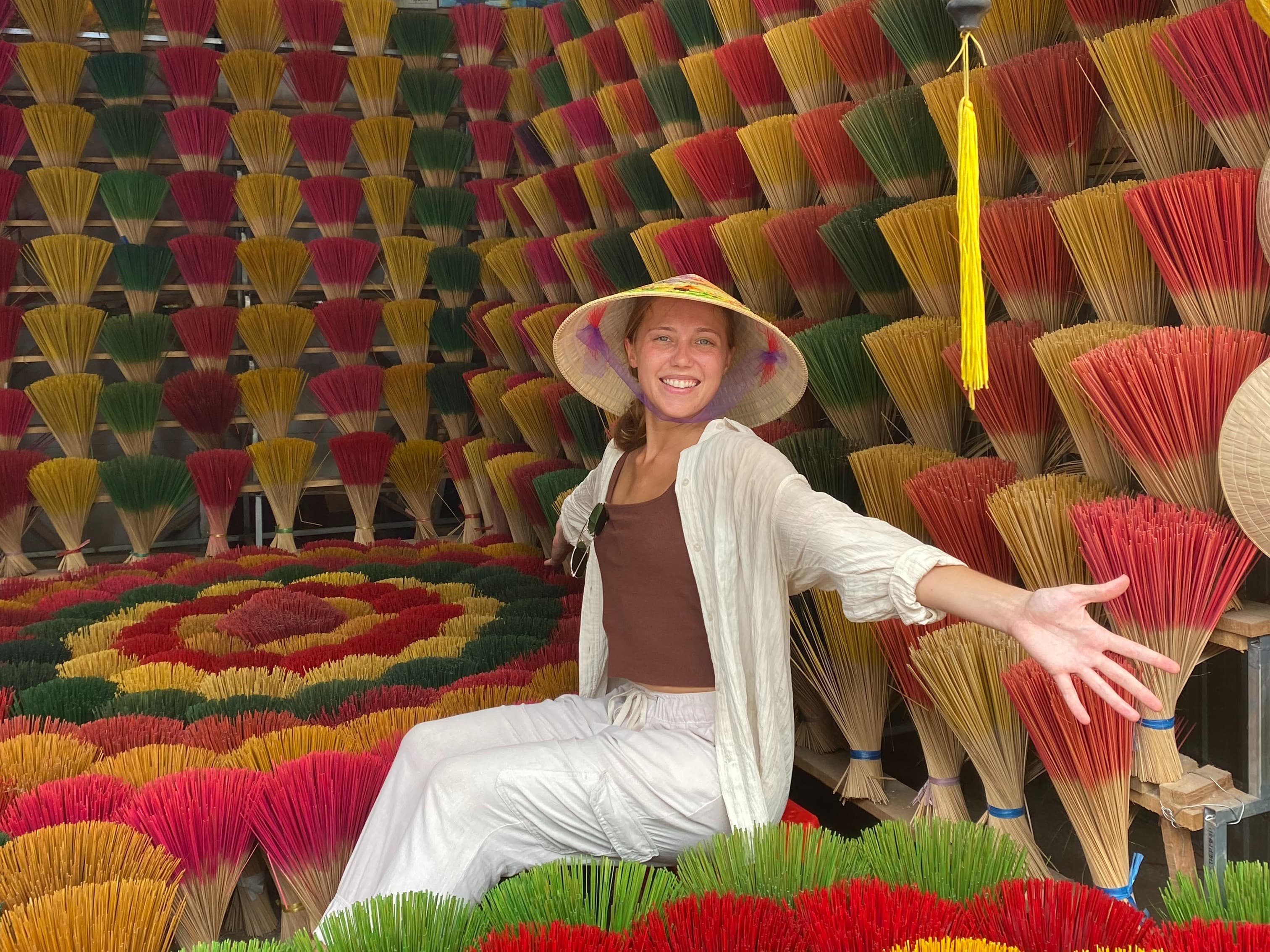 Travel advisor Isabel Smallman sitting in a store surrounded by colorful incense sticks on display.