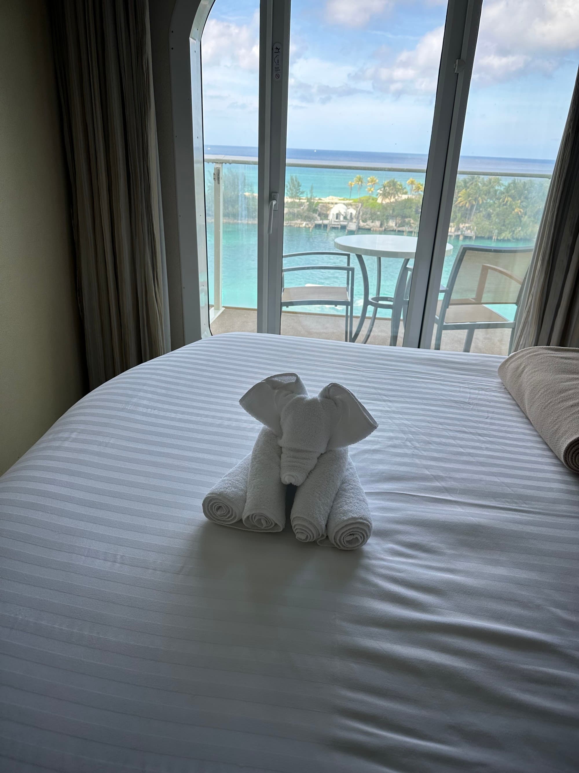 View of an animal shaped towel on a bed inside of a hotel.
