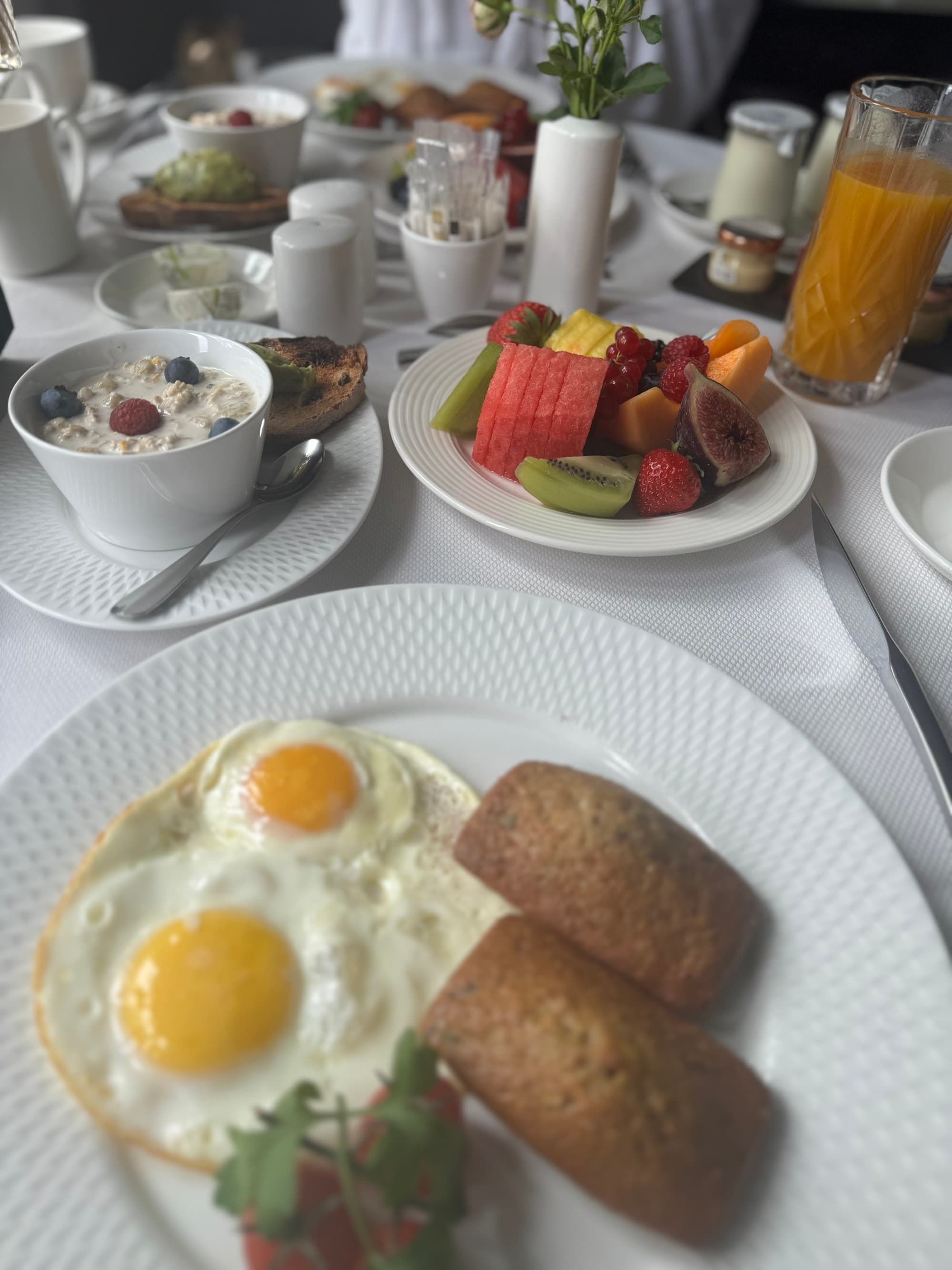 Breakfast table set with eggs and fresh fruit.