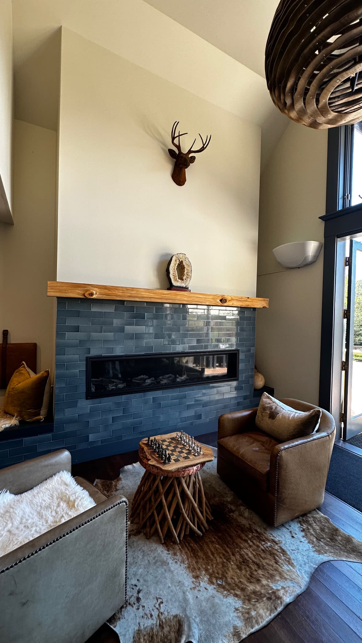 A room in a hotel suite with a chair in front of a modern fire place