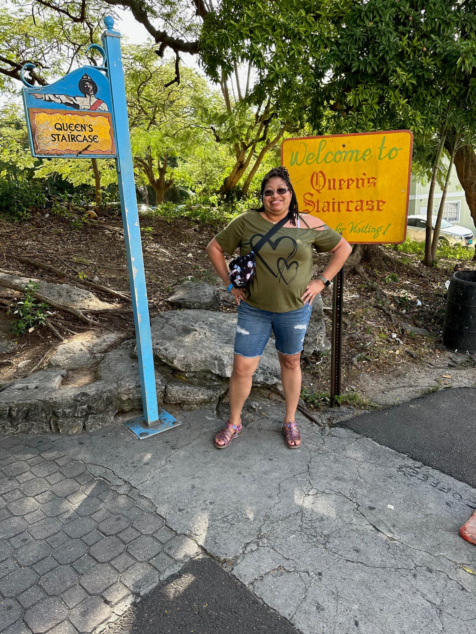 A person posing for a photograph outside between two signs