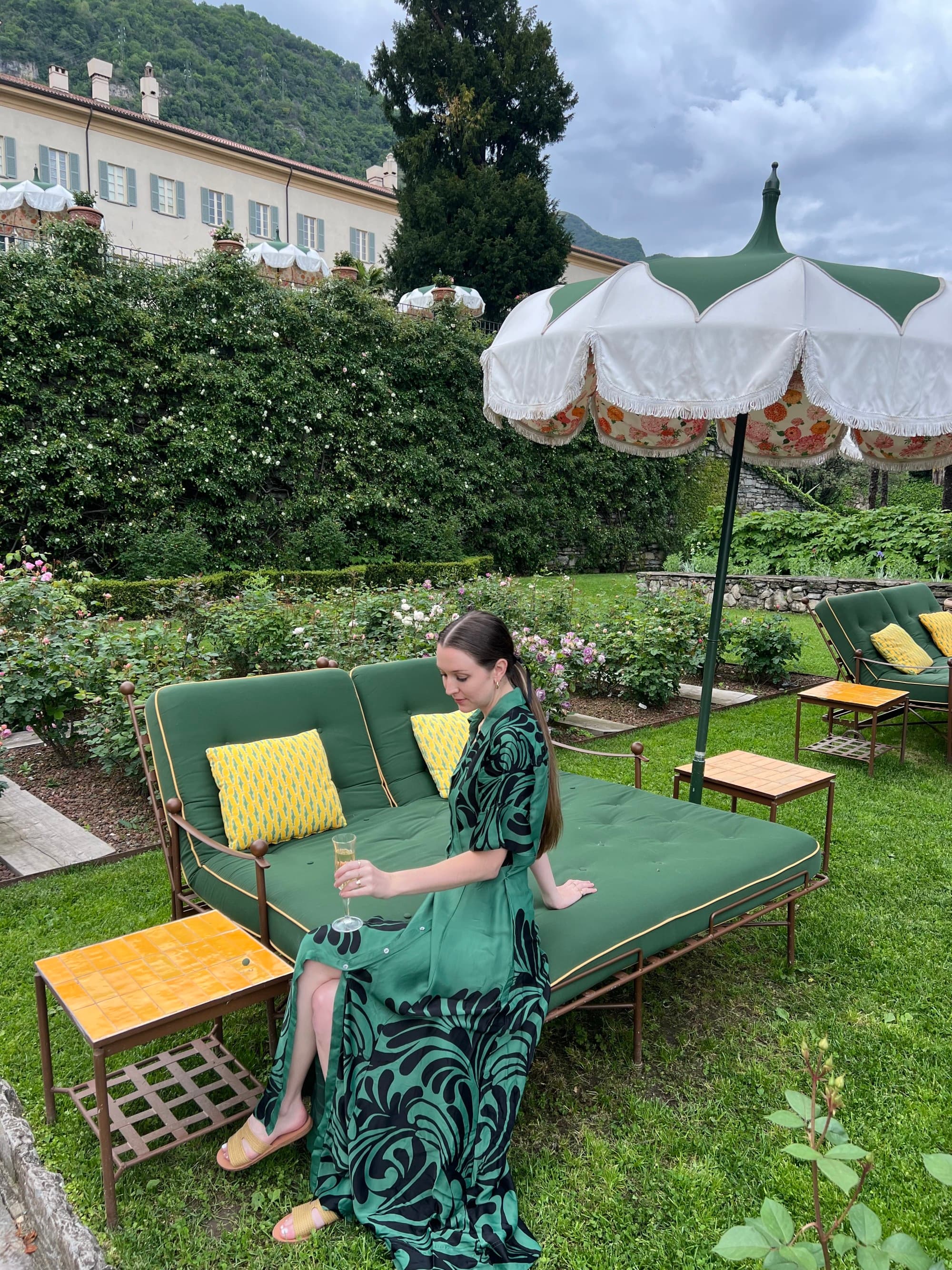 The lakeside sitting area provides comfy green double loungers with umbrellas on the lush lawn.
