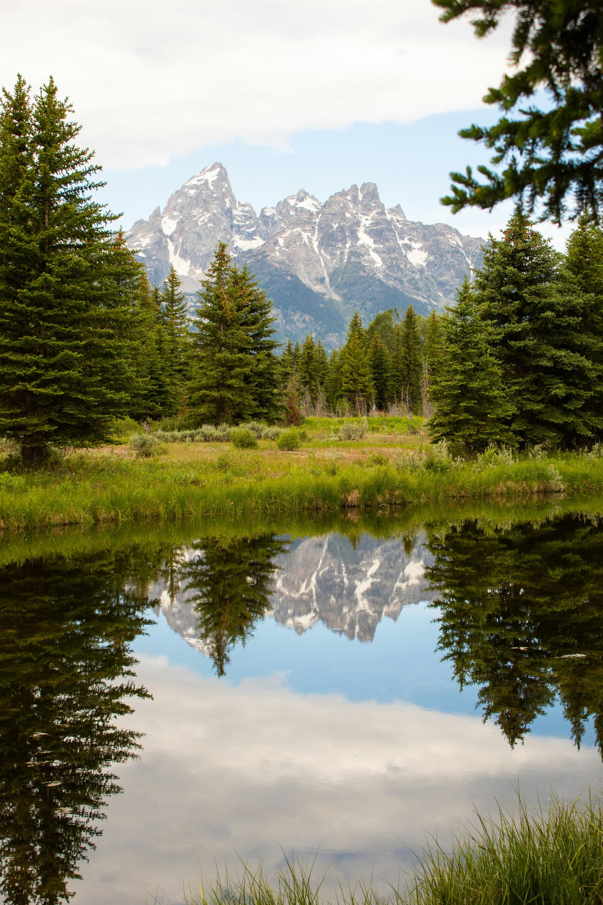 Lake with reflection of mountains and trees on a sunny day during the daytime.